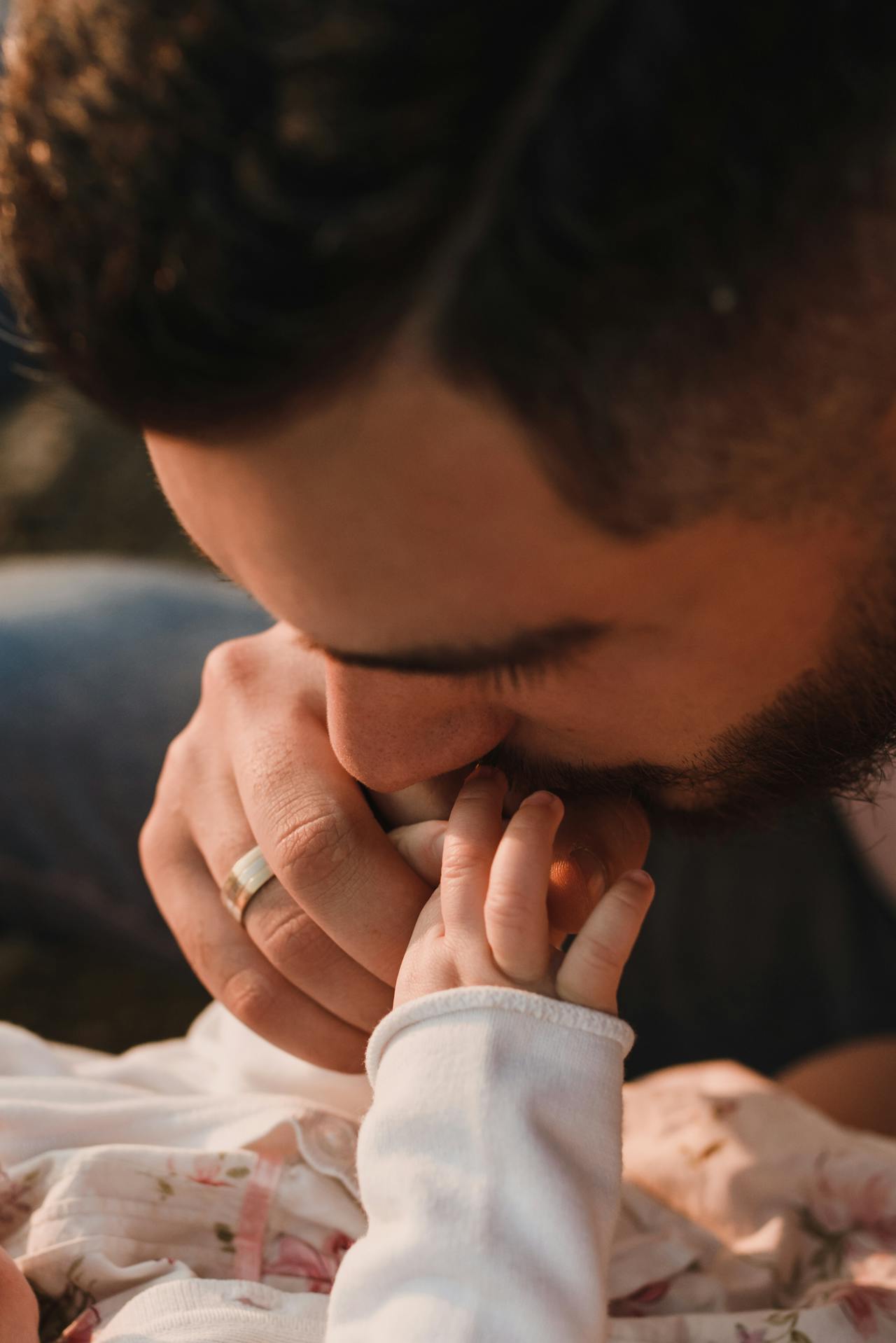Un homme embrassant son bébé sur la main | Source : Pexels