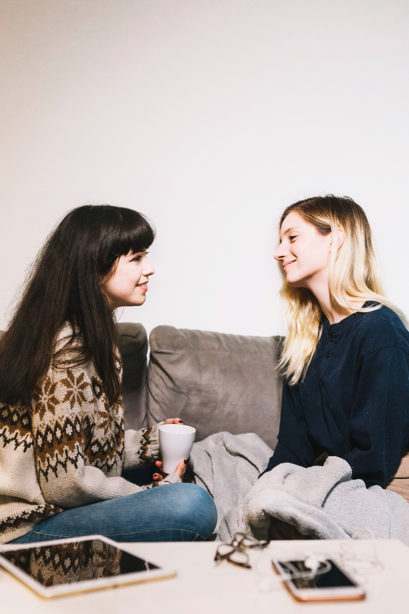Deux jeunes filles assises sur un canapé et discutant | Source : Freepik