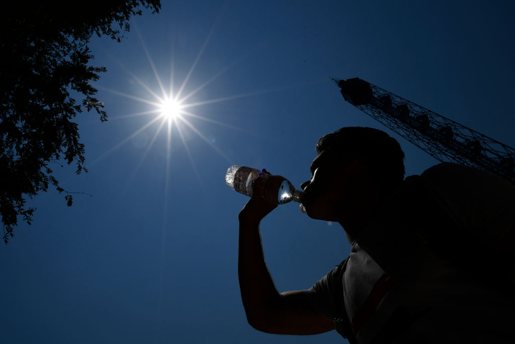 Un homme qui boit de l'eau pendant une chaude journée d'été. | Source : Getty Images