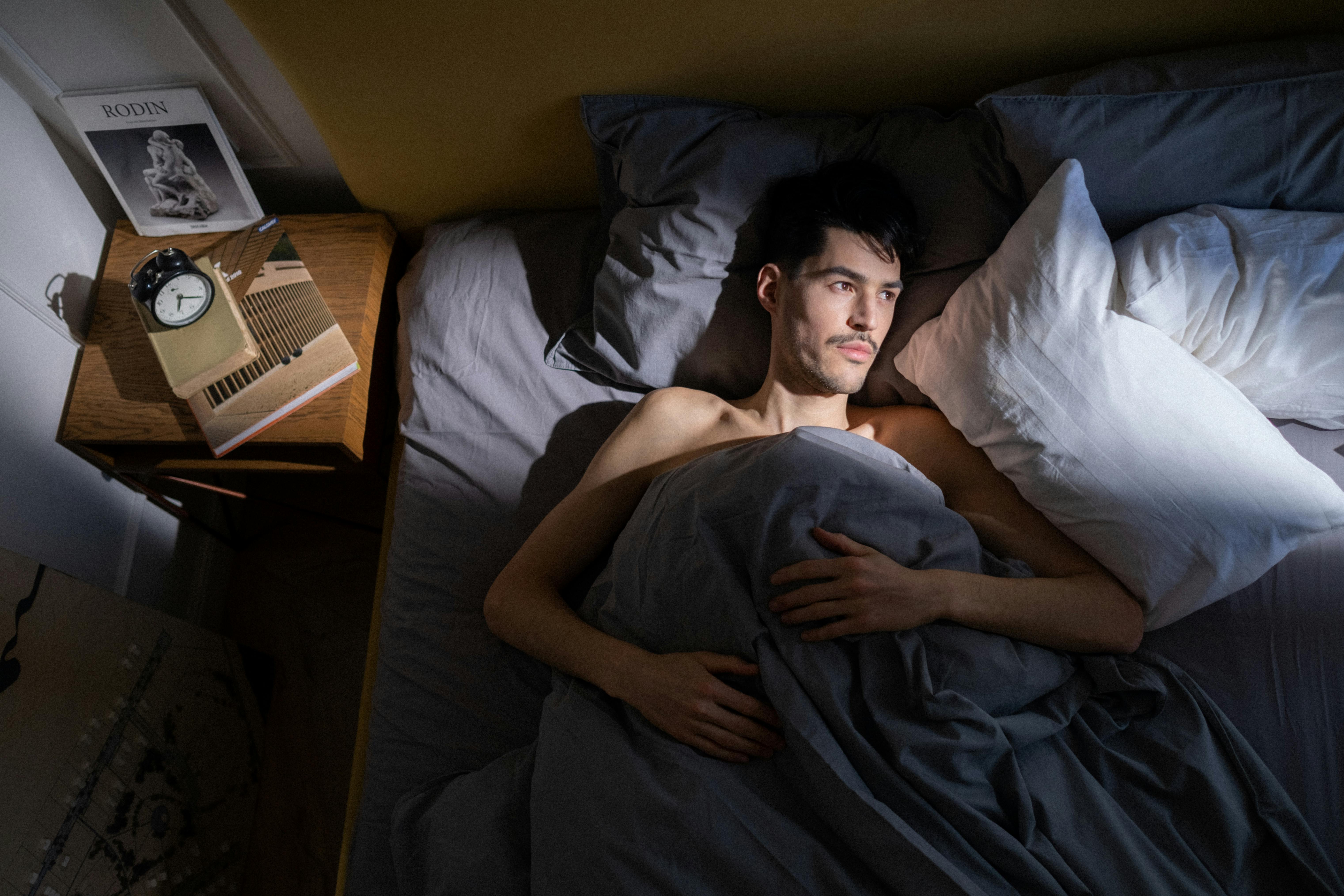 Homme allongé dans son lit | Source : Pexels