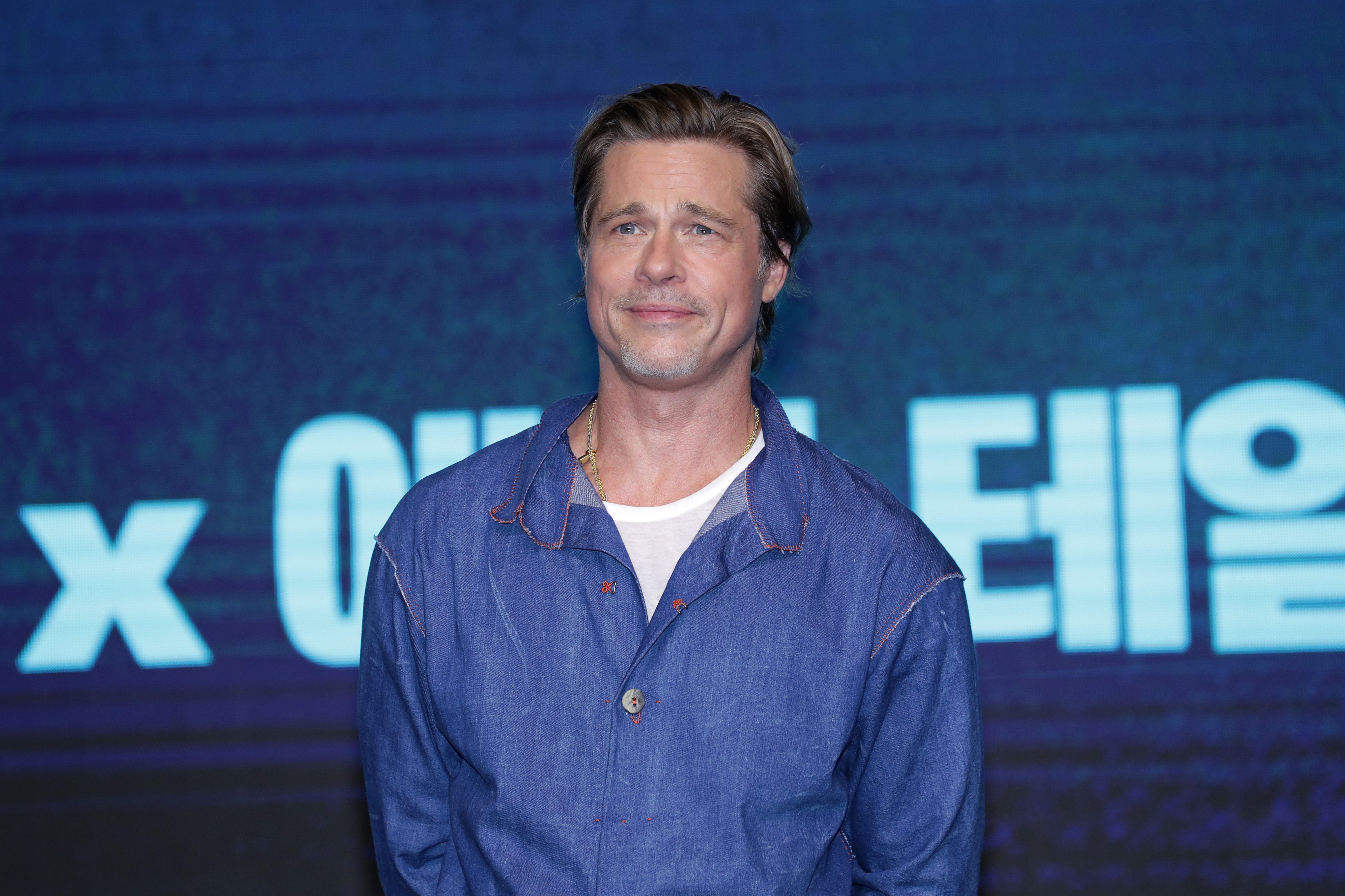 Brad Pitt lors d'une conférence de presse à Séoul, debout devant une toile de fond à l'effigie de la marque, dans le cadre de la promotion d'un film | Source : Getty Images