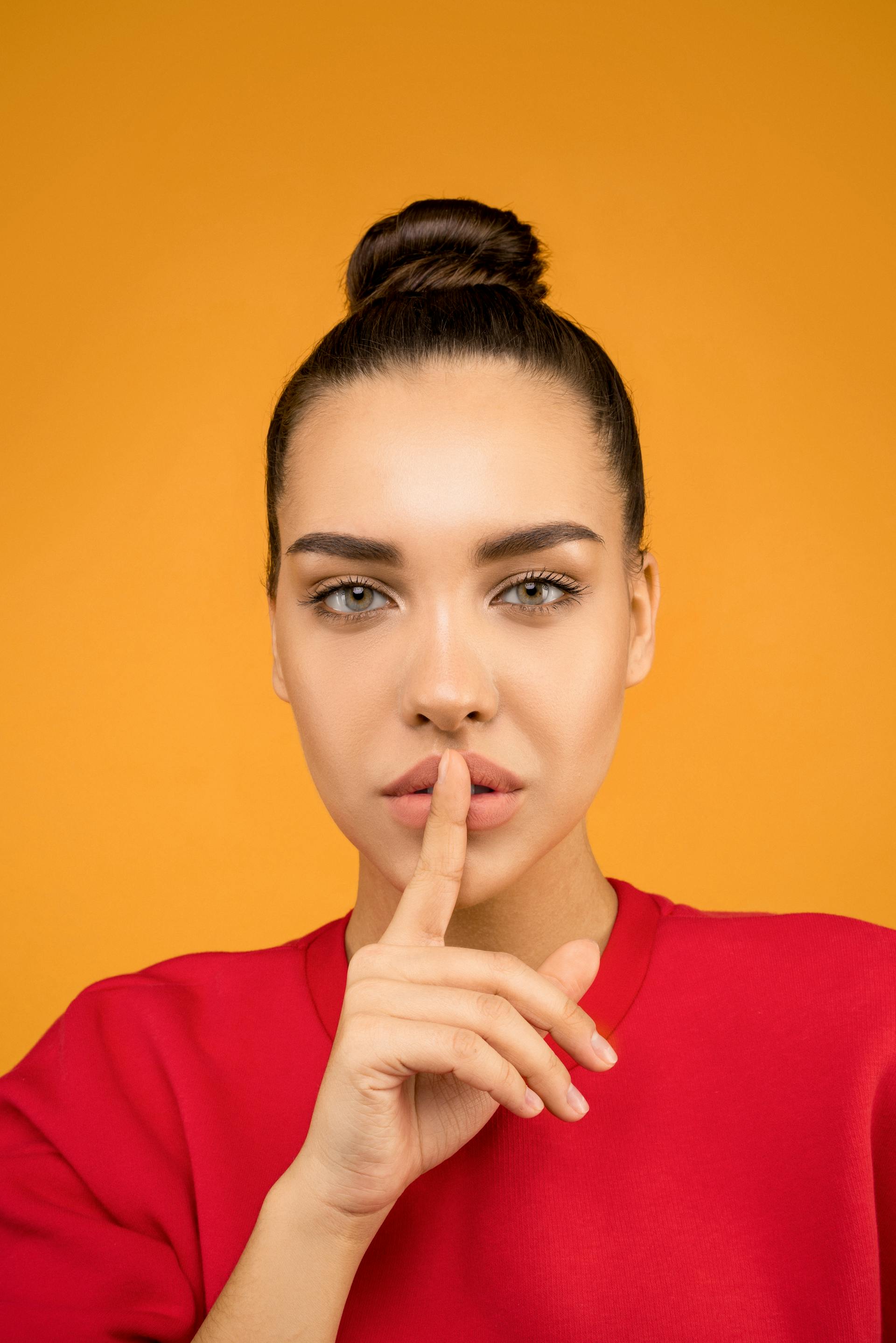 Une femme mettant un doigt sur ses lèvres | Source : Pexels