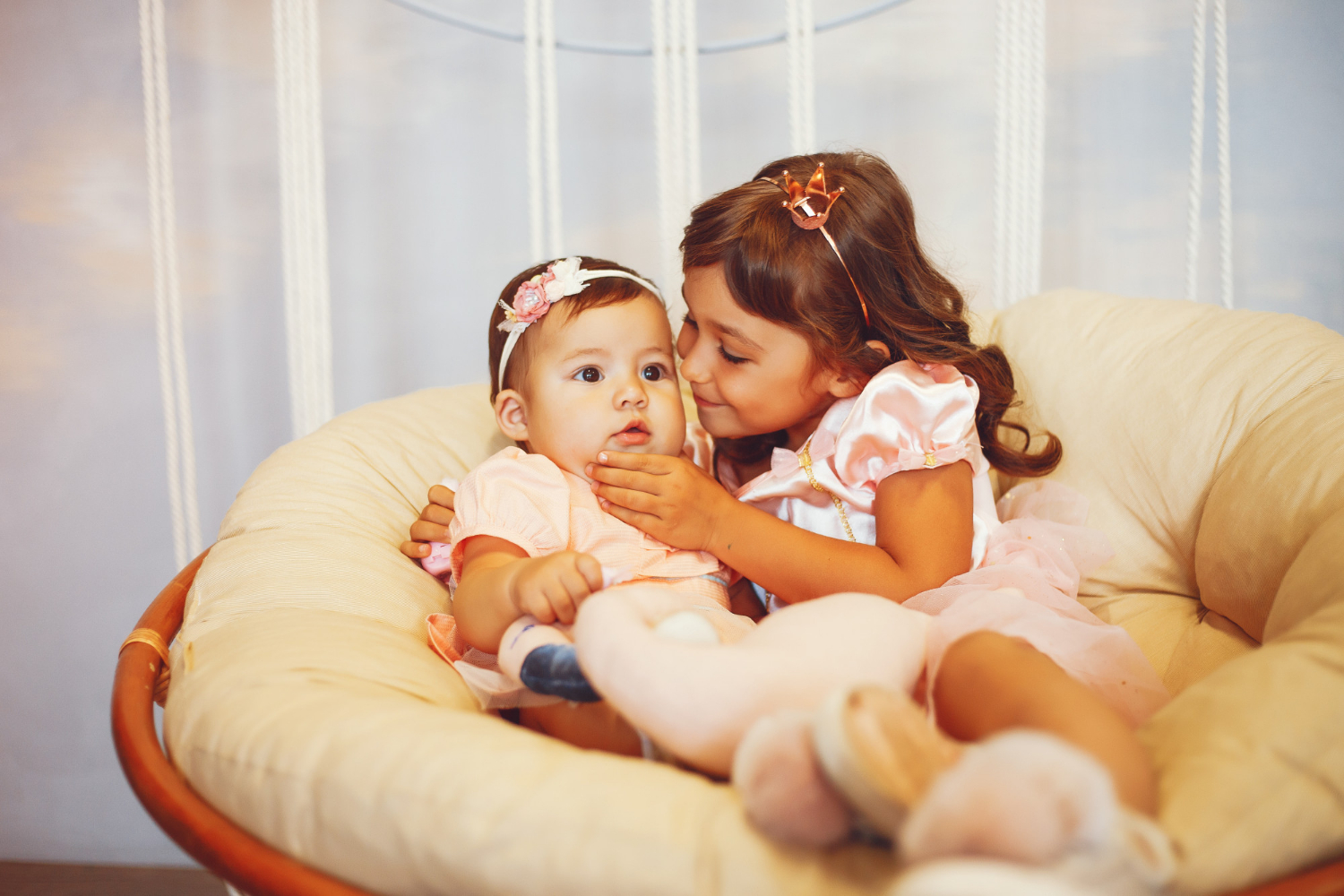 Une petite fille et un bébé assis sur une chaise | Source : Freepik