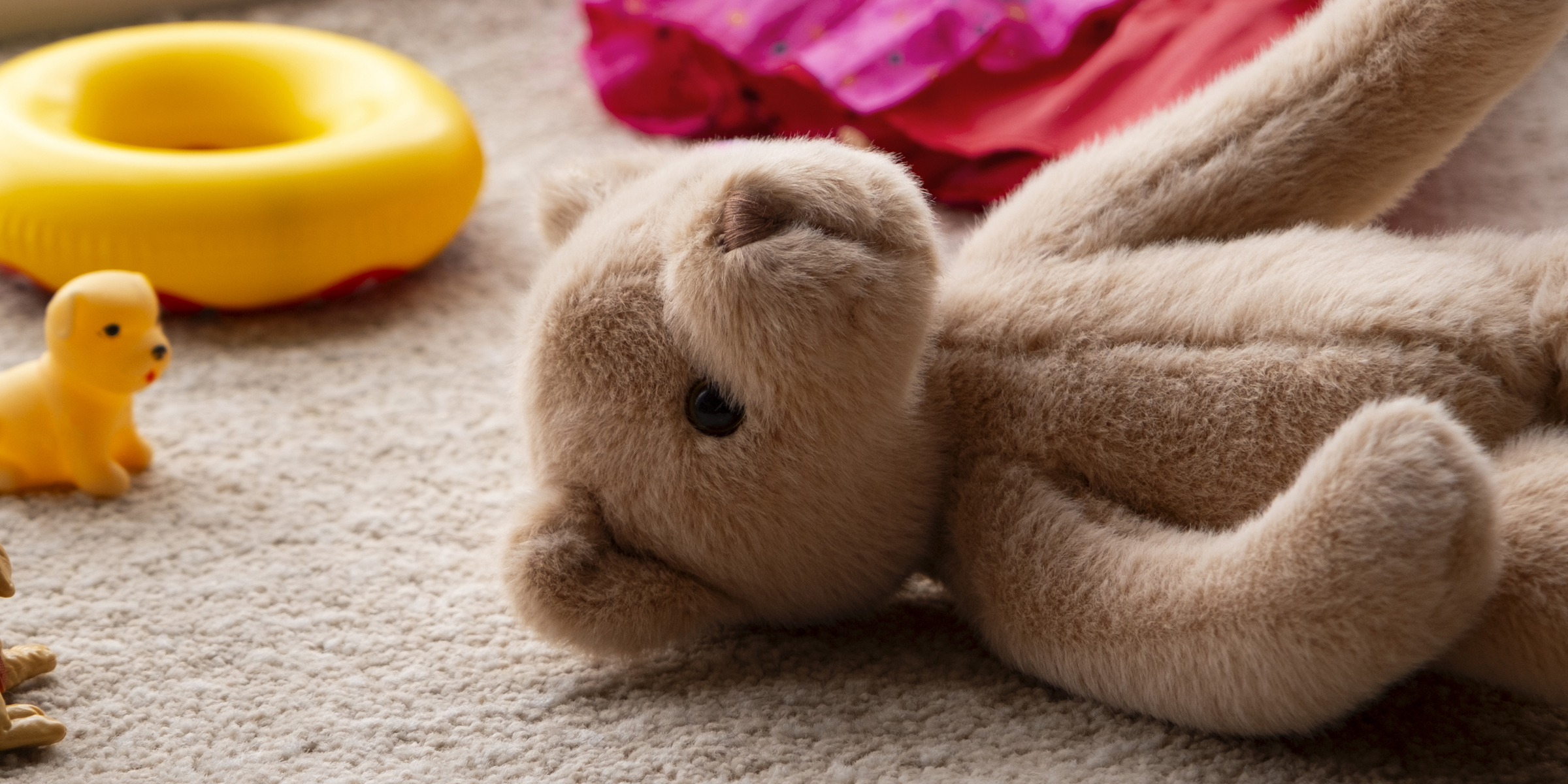 Un ours en peluche couché sur un sol recouvert de moquette | Source : Freepik