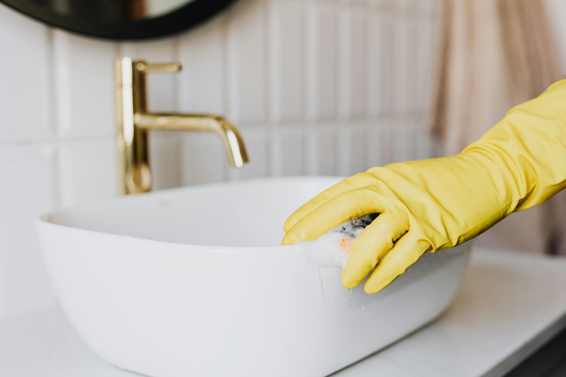 Une personne nettoyant un évier de salle de bain | Source : Pexels