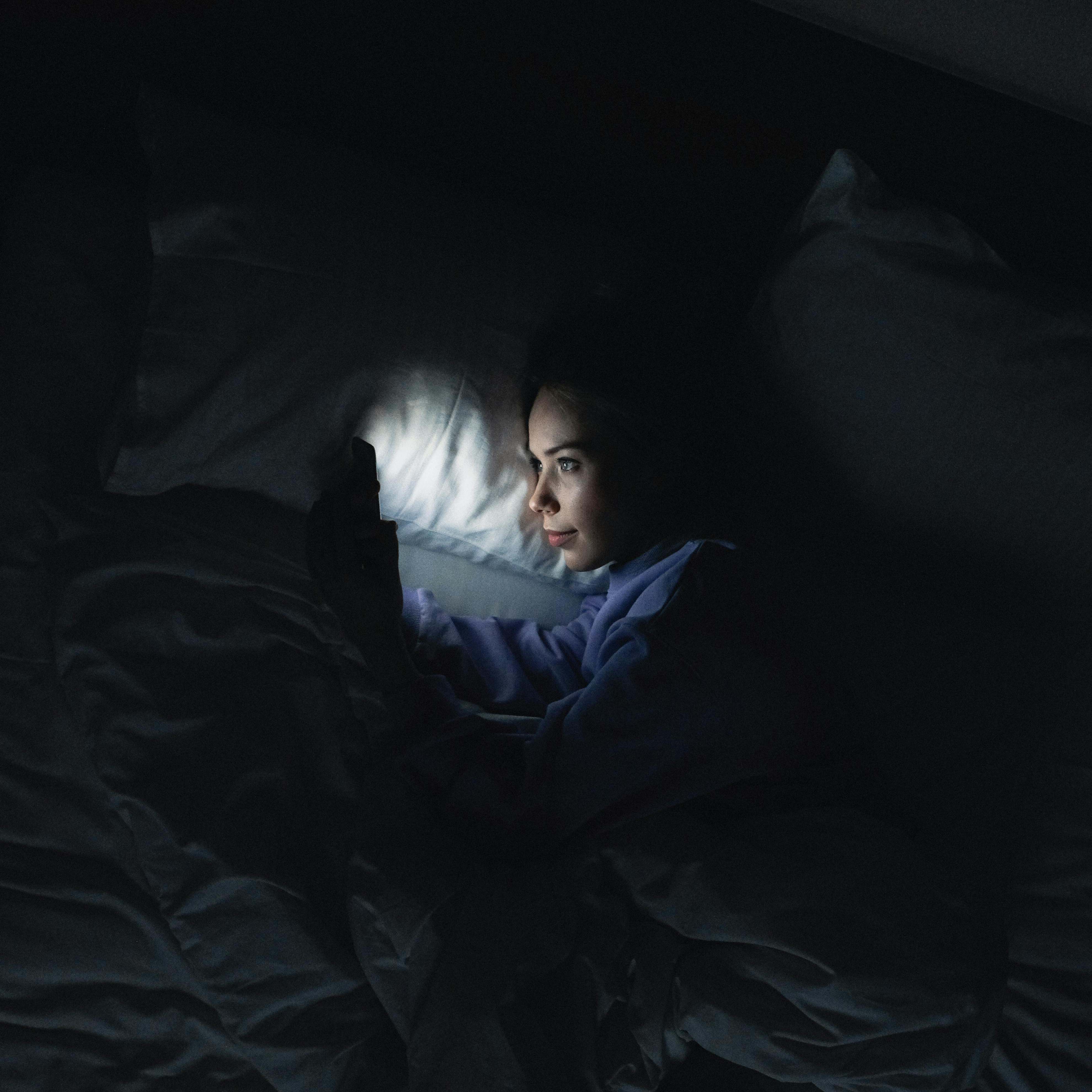 Une femme qui utilise son téléphone au lit | Source : Pexels