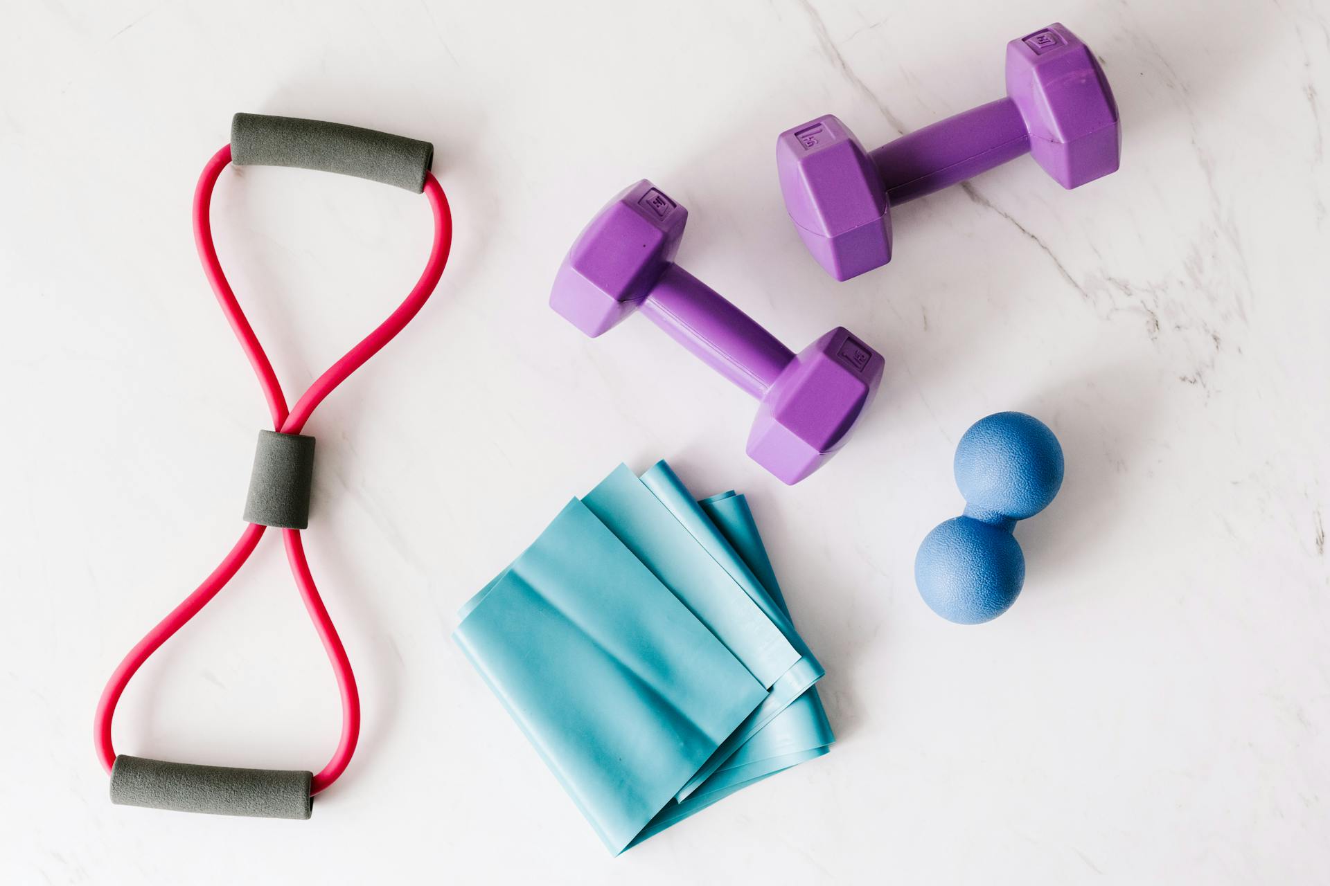 Un ensemble d'appareils de fitness placés sur une surface en marbre | Source : Pexels