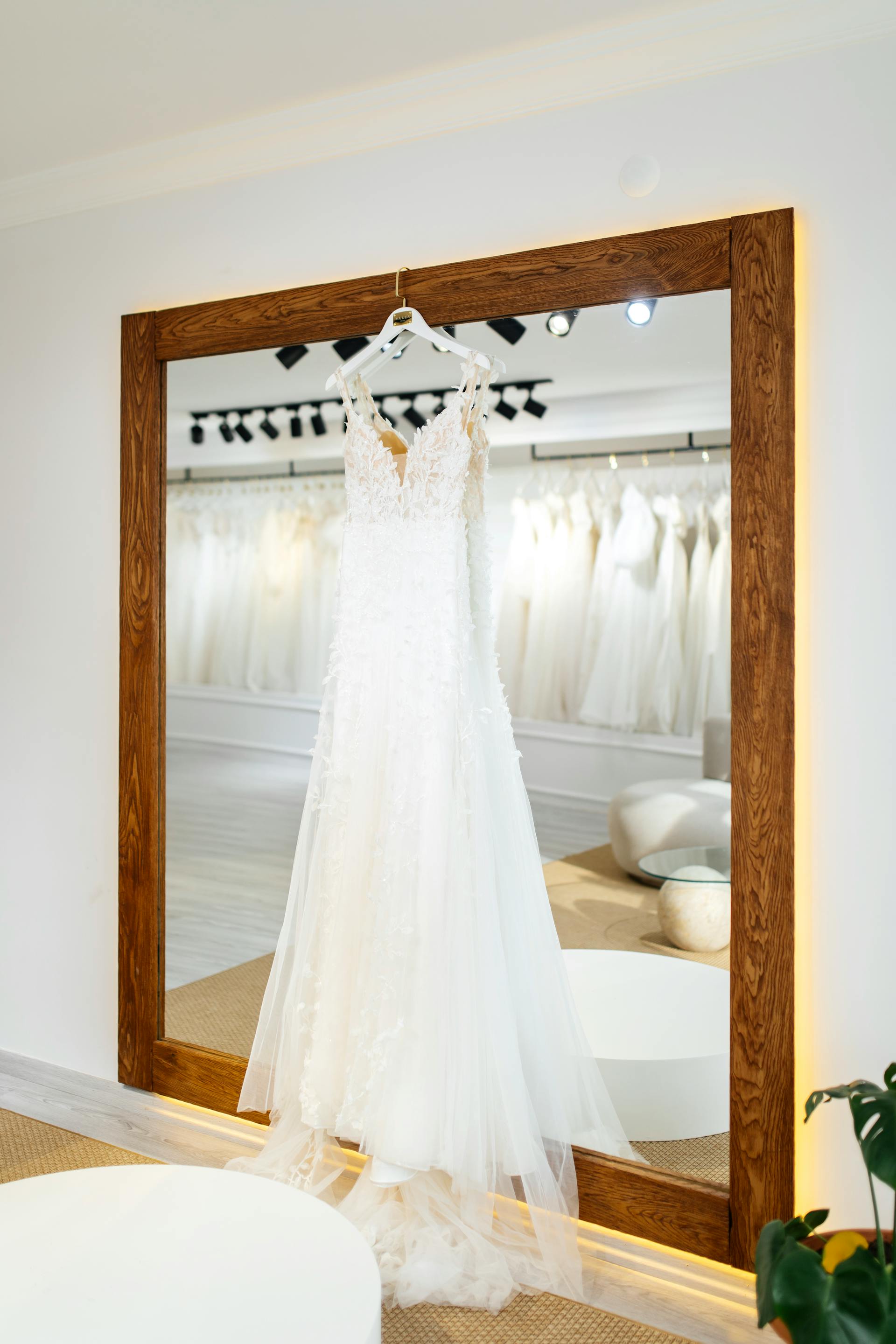 Une robe de mariée blanche suspendue à un cadre de miroir | Source : Pexels