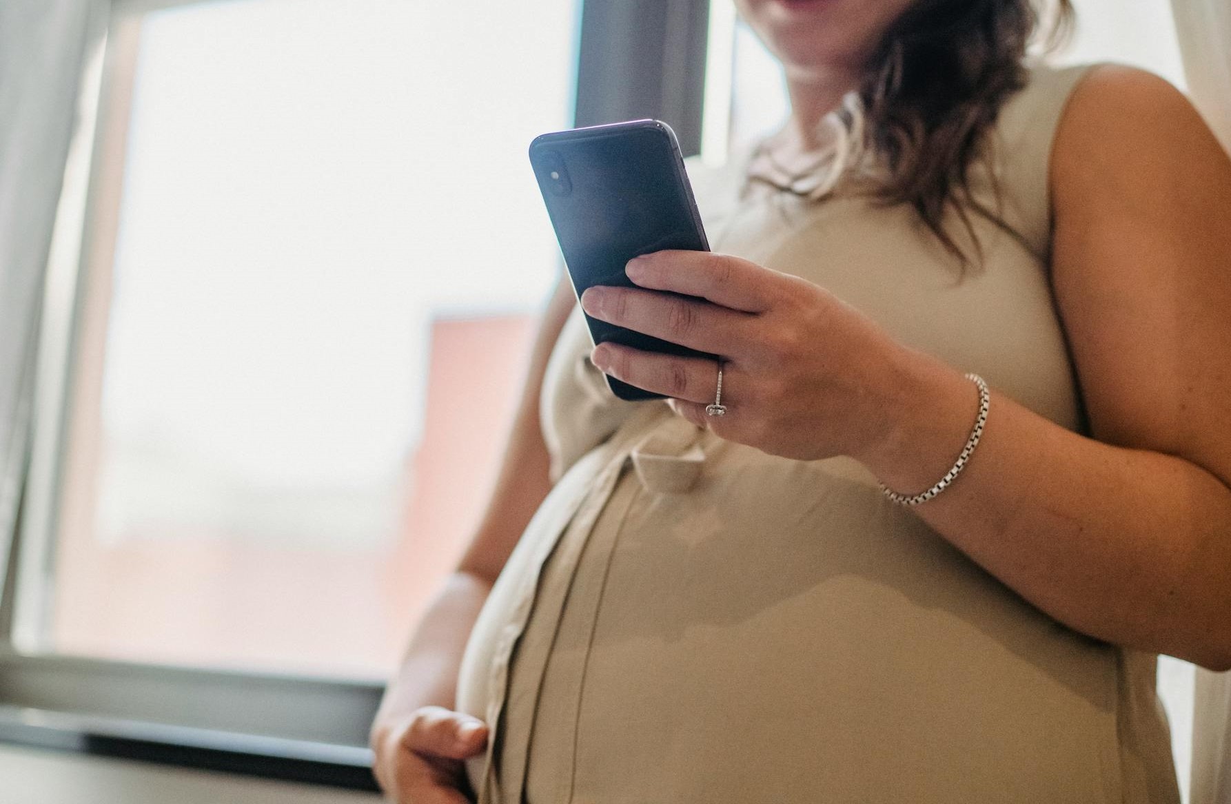 Une femme enceinte tenant un smartphone | Source : Pexels
