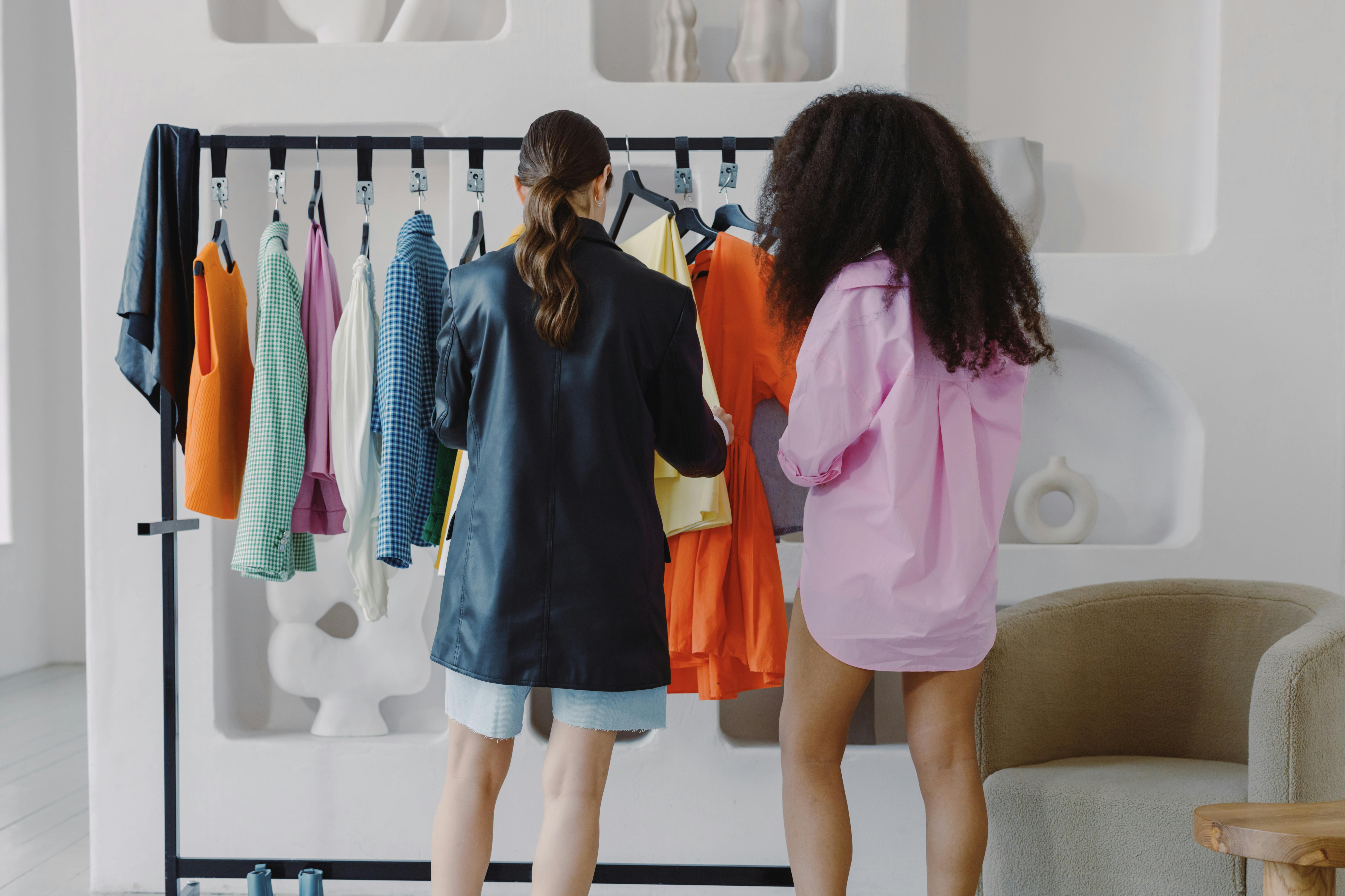 Des femmes regardent des vêtements sur un présentoir | Source : Pexels
