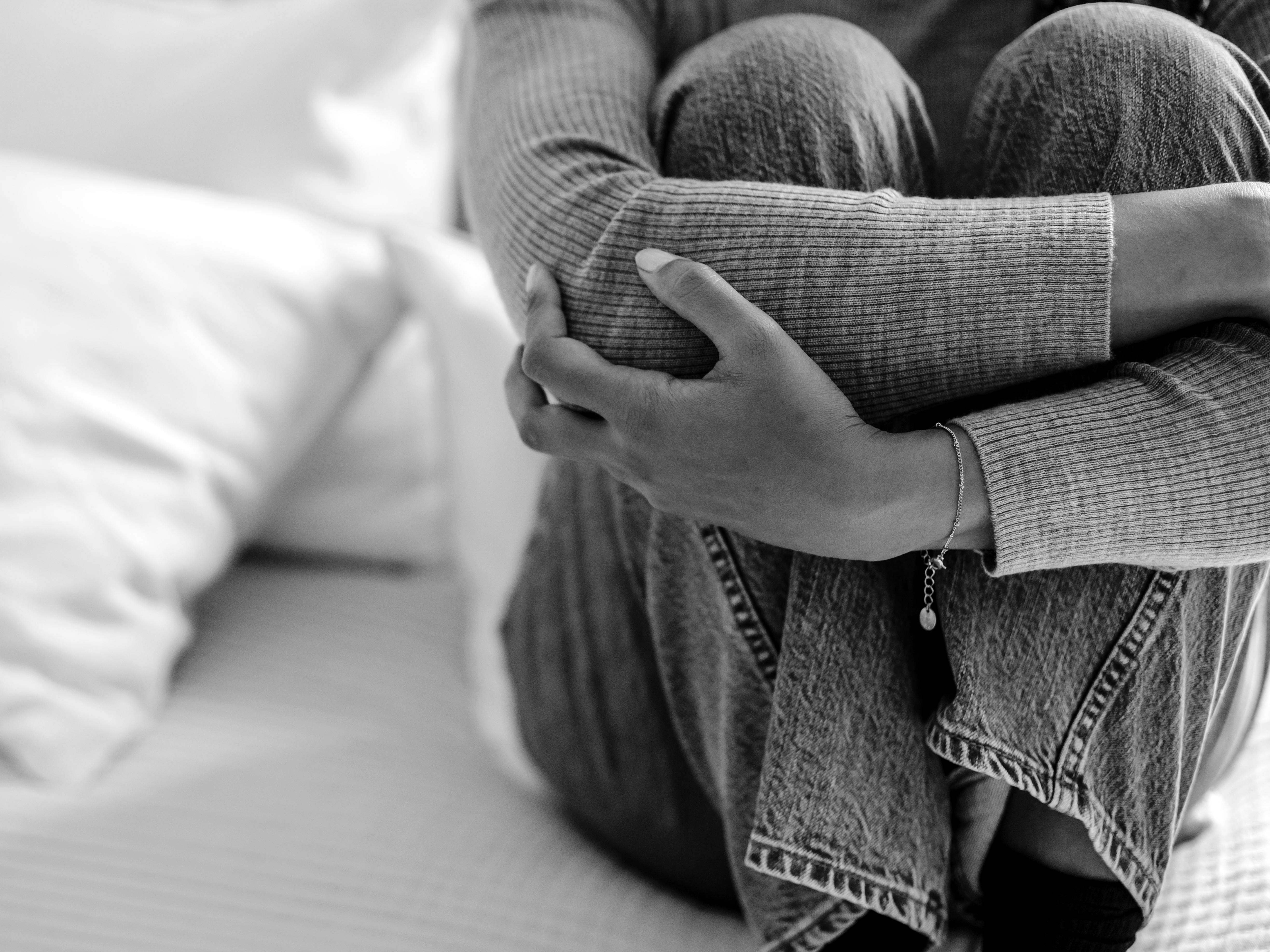 Une femme accroupie sur un lit. | Source : Pexels