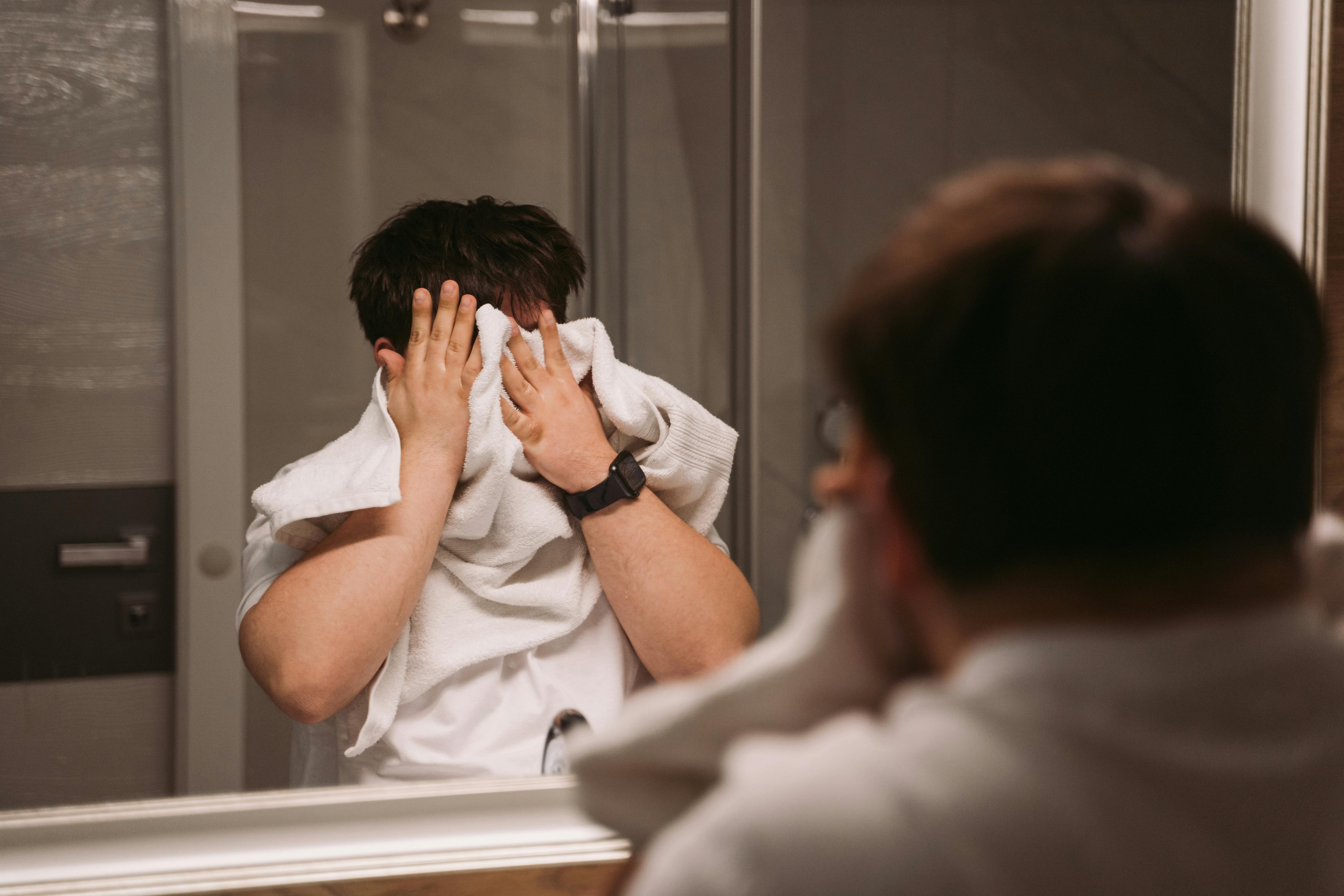 Un homme s'essuyant le visage avec une serviette | Source : Pexels