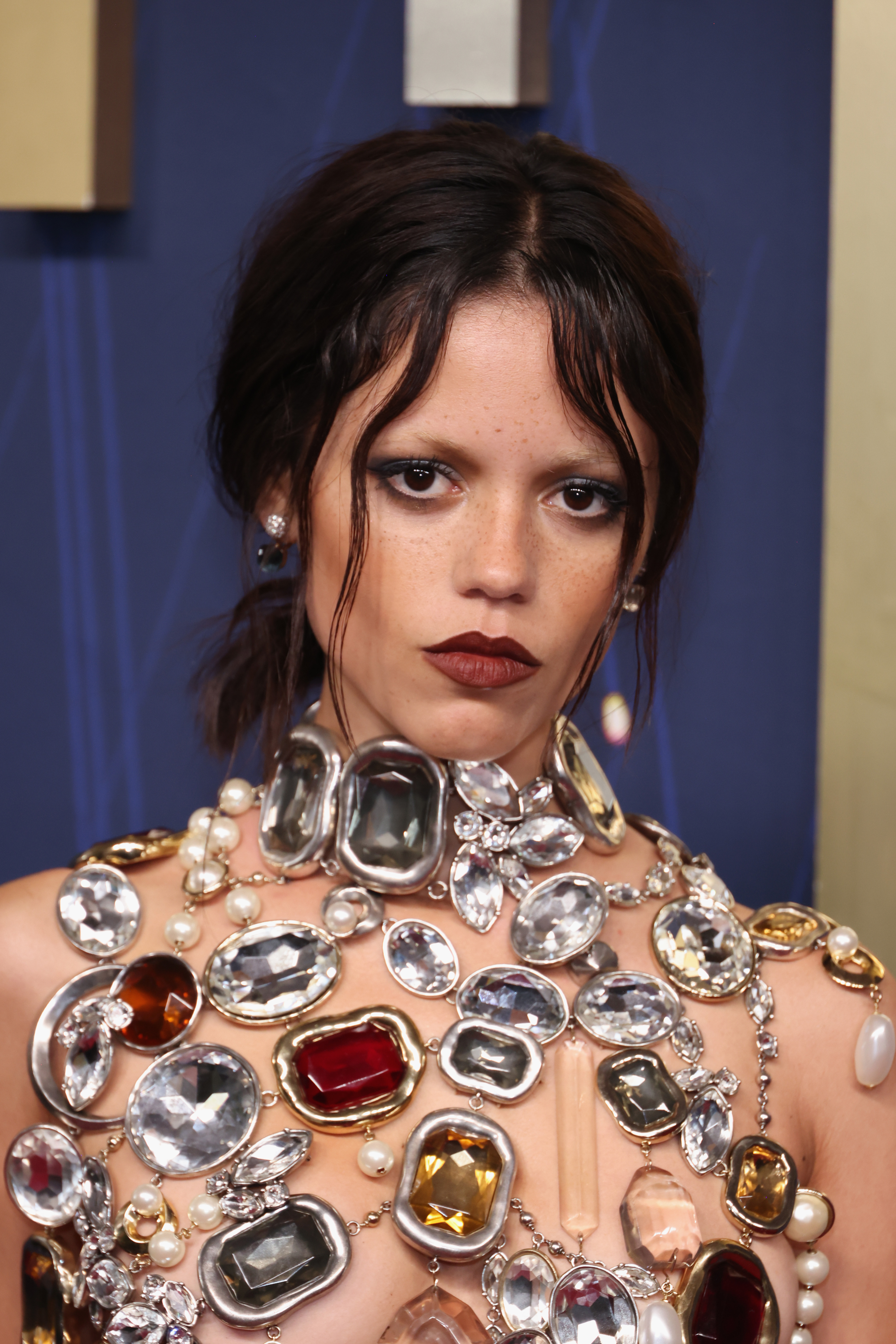 Un gros plan montre le haut porté par Jenna Ortega qui a stupéfié les fans. Il s'agit d'un modèle scintillant ressemblant à un soutien-gorge, composé de rangées de perles et de pierres précieuses dans des tons de gris, d'argent et de jaune, qui brillent toutes sous la lumière.
