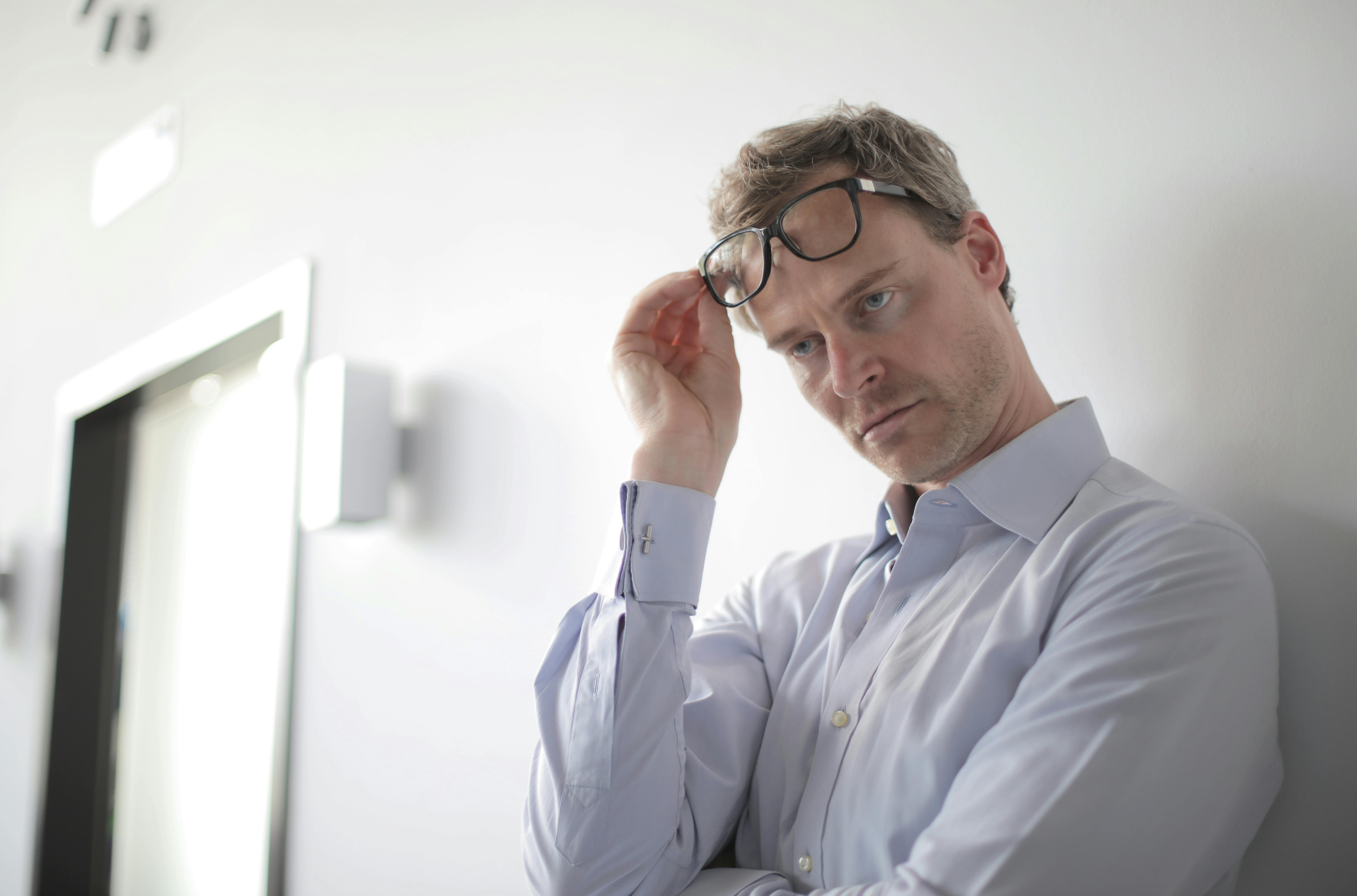 Un homme debout, les lunettes sur la tête | Source : Pexels
