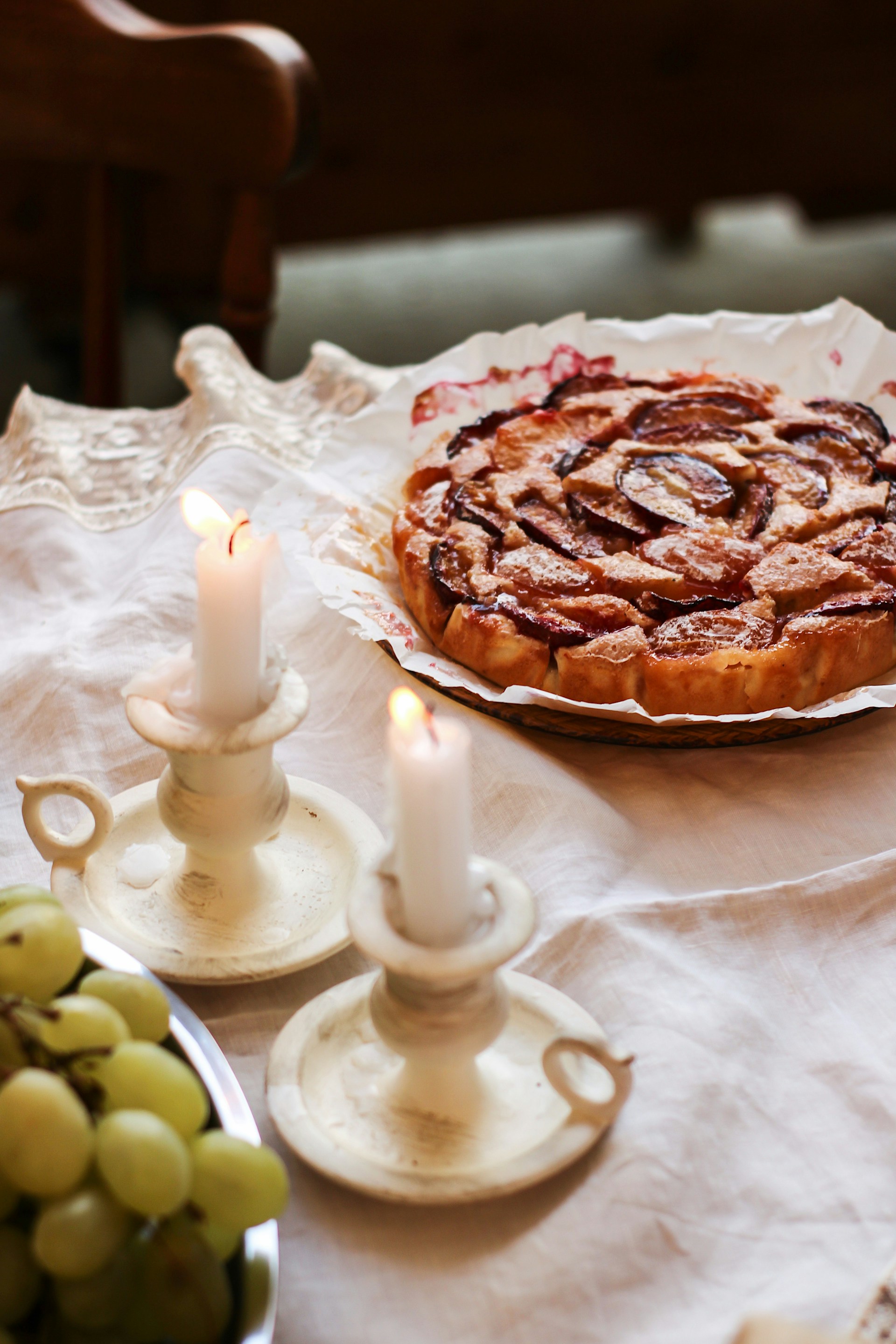 Un bol de raisins, des bougies et une assiette de tarte sur la table | Source : Unsplash