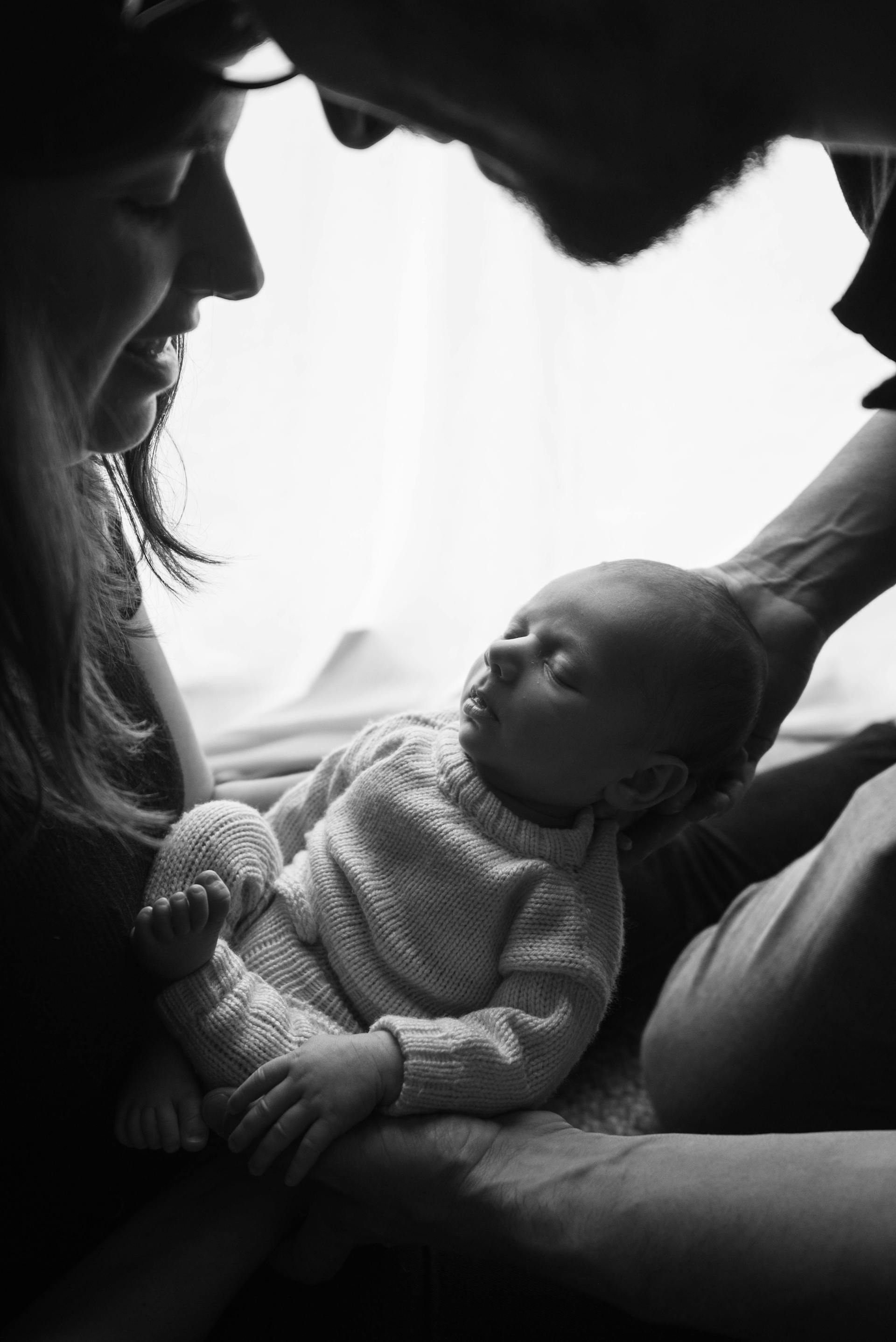 Une photo en niveaux de gris d'un couple tenant un nouveau-né | Source : Pexels