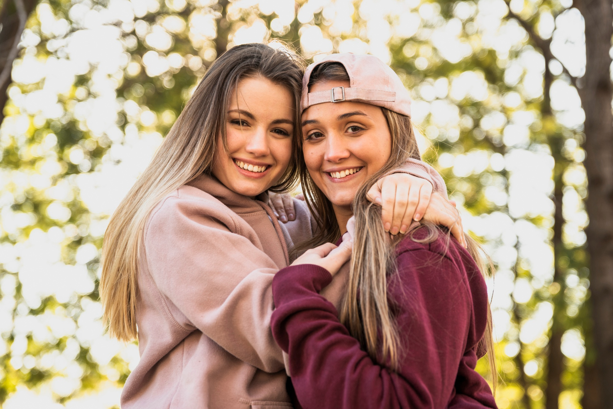 Deux jeunes filles qui regardent l'appareil photo et sourient | Source : Freepik