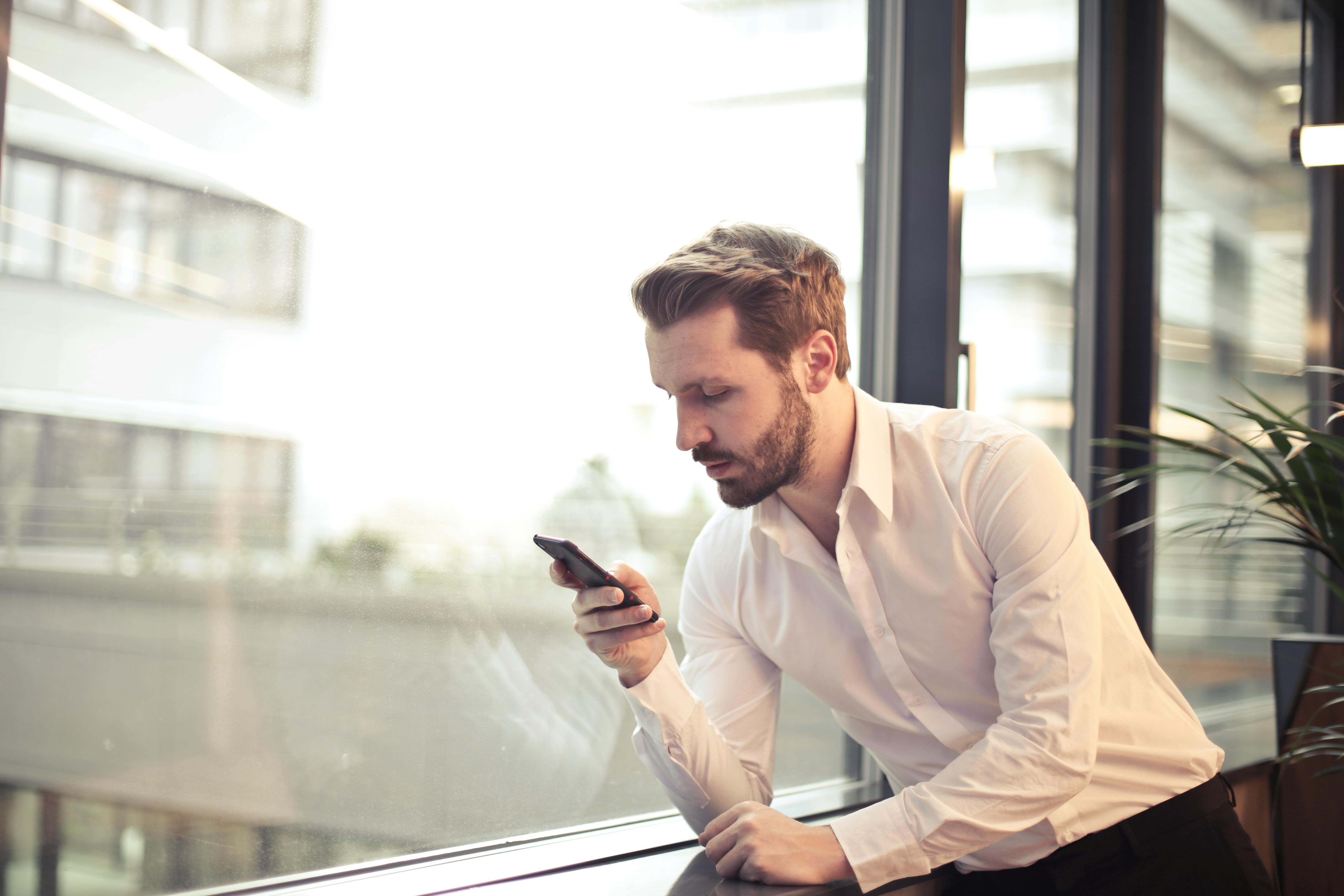 Un homme étudiant son téléphone portable | Source : Pexels