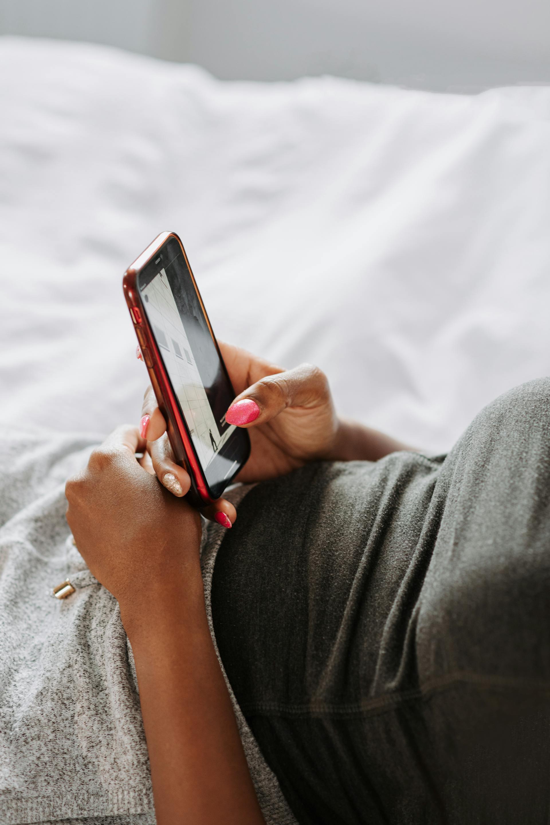 Une femme utilisant son téléphone au lit | Source : Pexels
