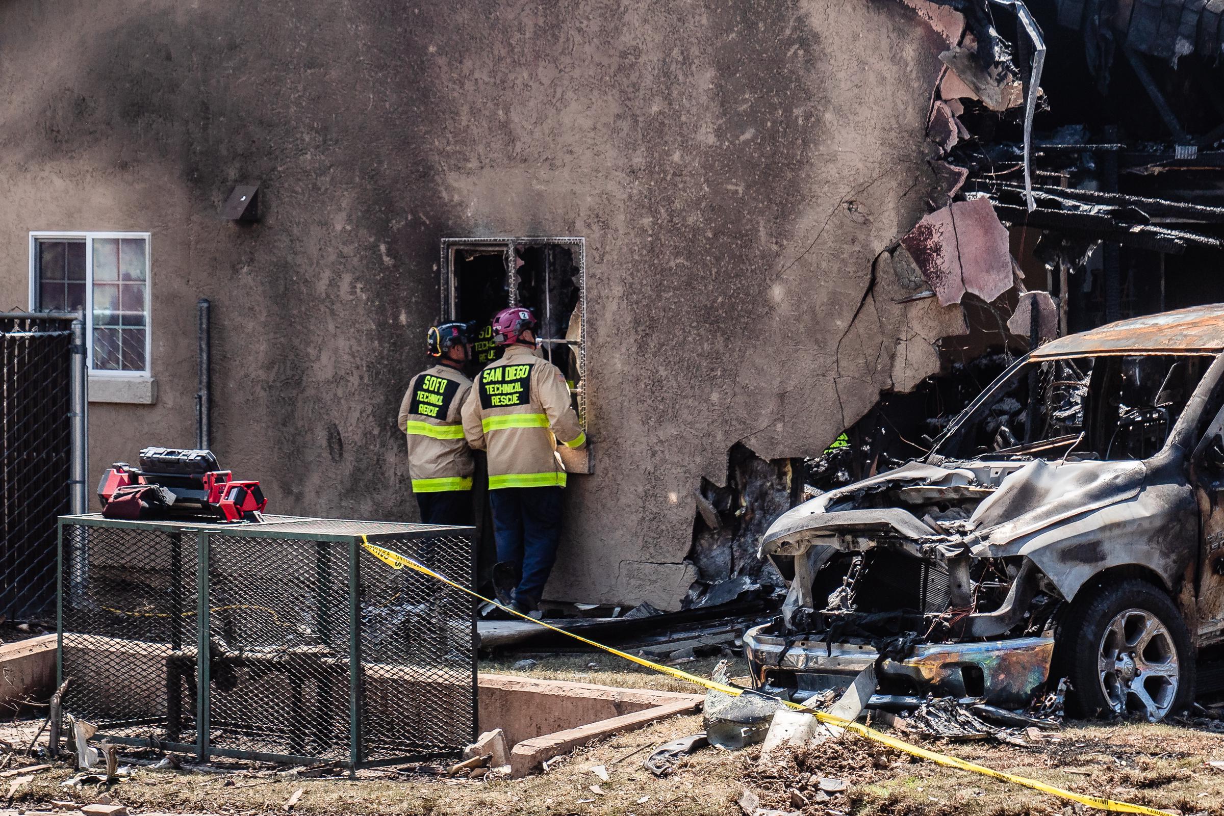 Les équipes de pompiers-sauveteurs de San Diego examinent une maison endommagée à San Diego, en Californie, après qu'un petit avion se soit écrasé dans le quartier, le 22 mai 2025 | Source : Getty Images