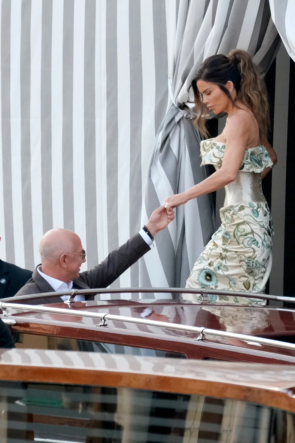 Jeff Bezos aidant Lauren Sánchez, qui porte une robe de couture Schiaparelli, à monter à bord d'un bateau-taxi à Venise le 26 juin 2025. | Source : Getty Images