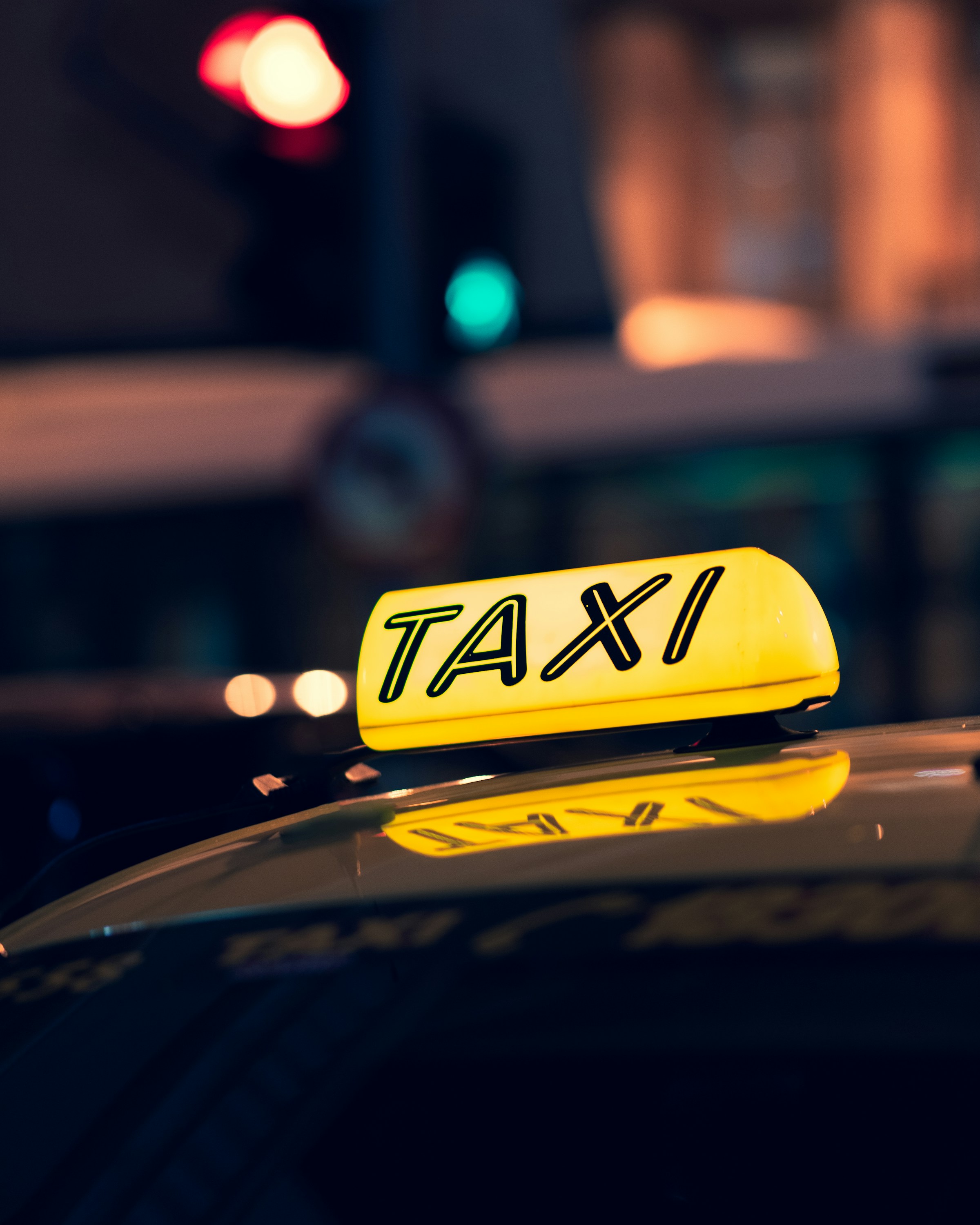 Gros plan d'un taxi sur la route pendant la nuit | Source : Unsplash