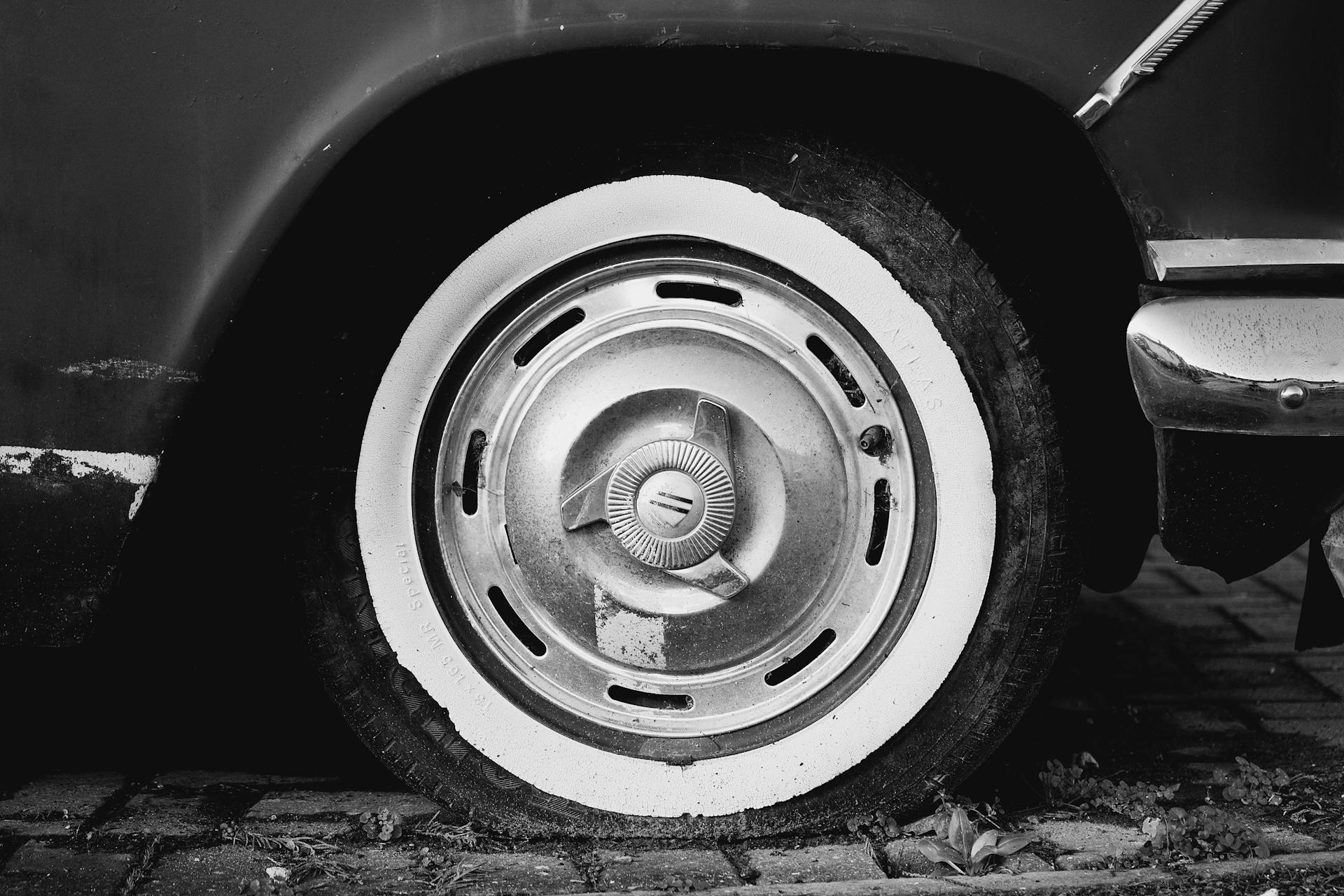 Photo en niveaux de gris d'un pneu de voiture crevé | Source : Pexels