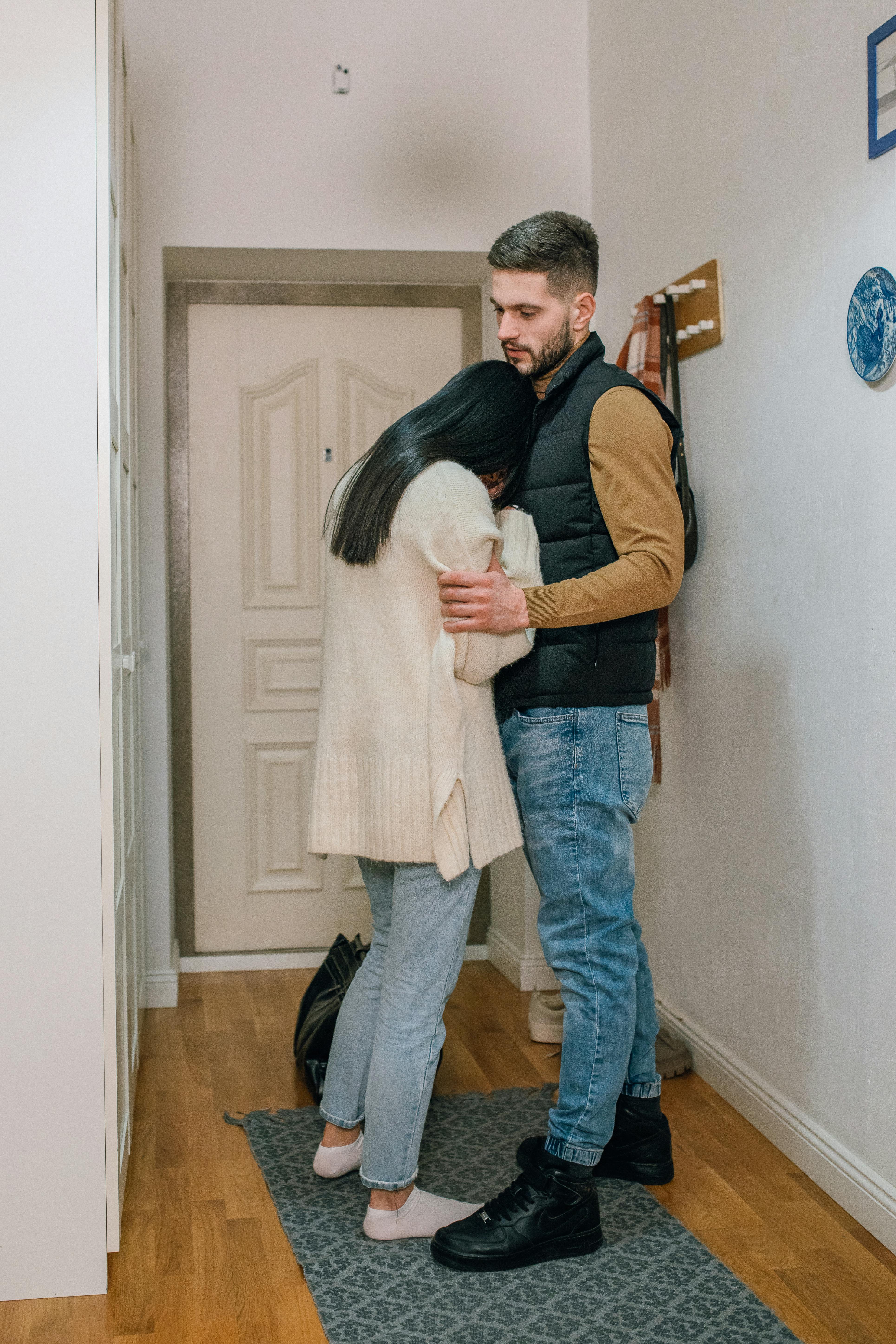 Un homme semble imperturbable alors qu'une femme pleure dans ses bras | Source : Pexels