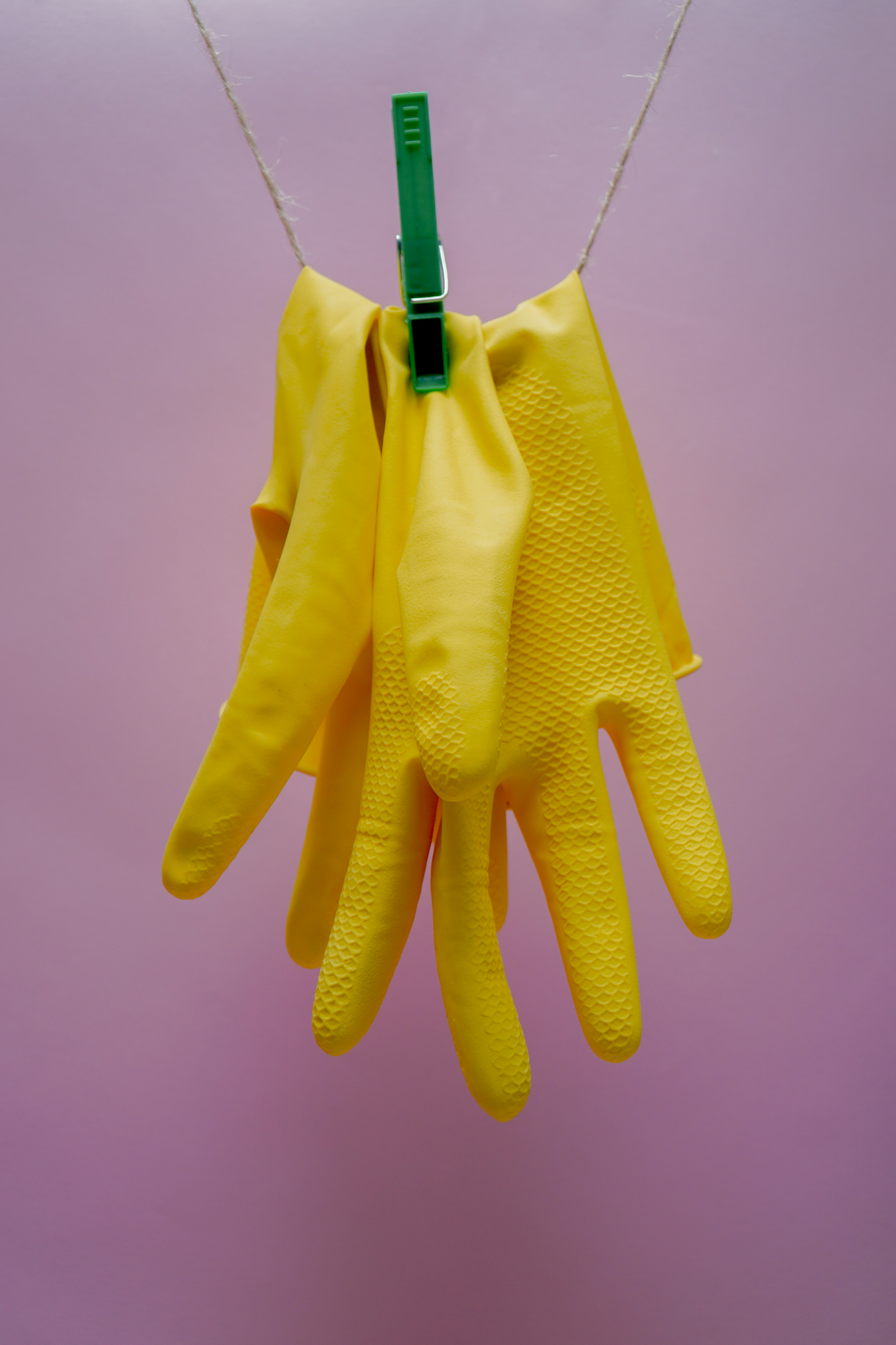Gants jaunes suspendus à une patère | Source : Unsplash