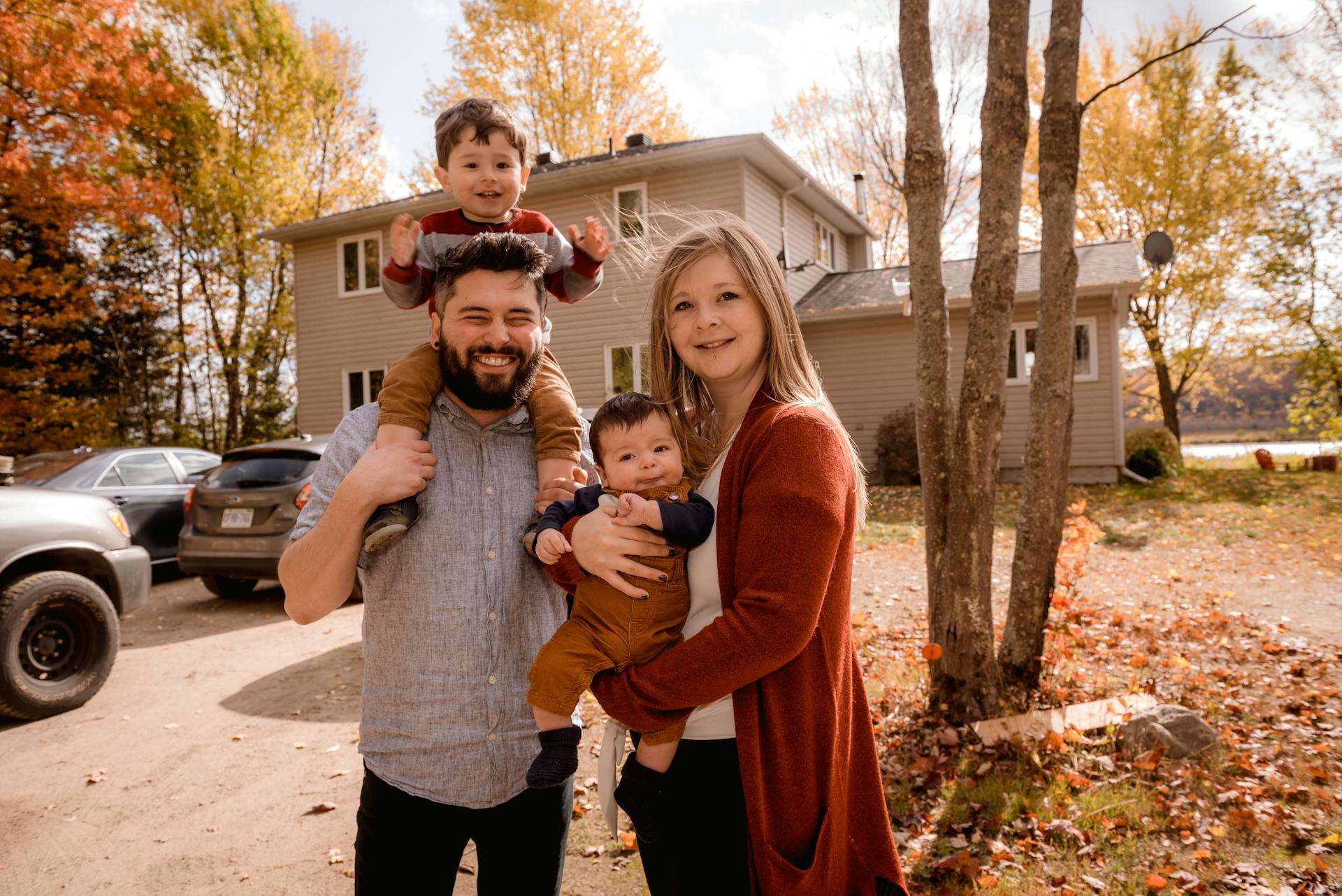 Une famille heureuse se tenant devant une maison | Source : Pexels