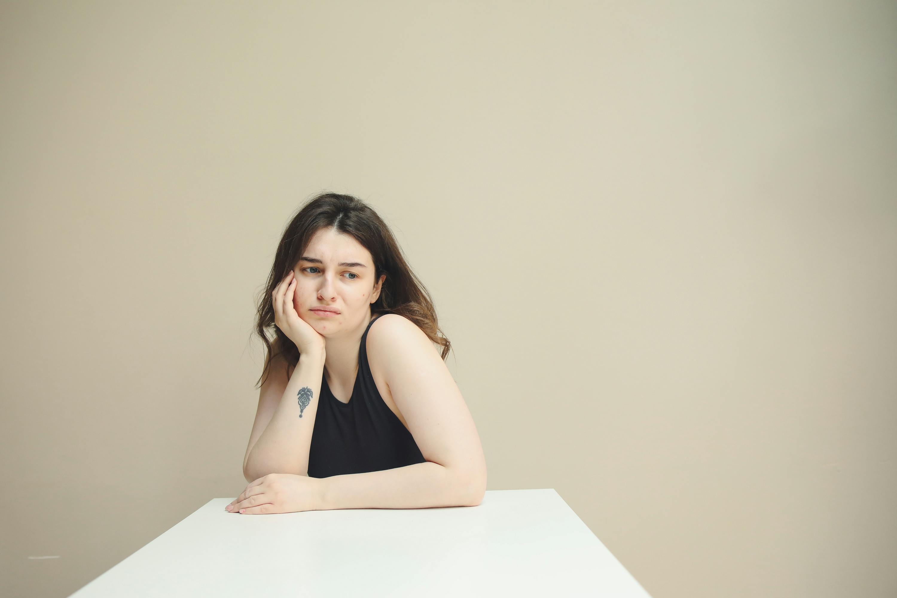Une femme pensive assise à une table | Source : Pexels