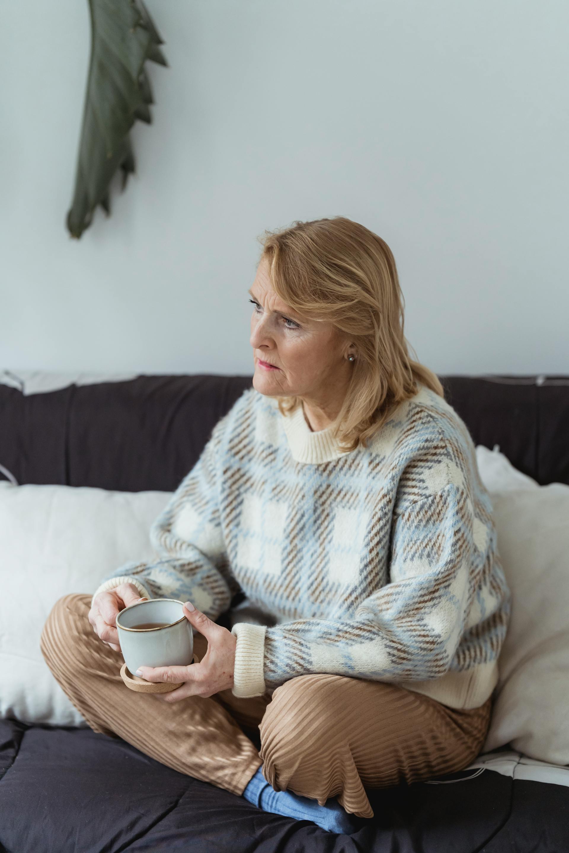 Une femme d'âge moyen tenant une tasse et regardant quelqu'un | Source : Pexels