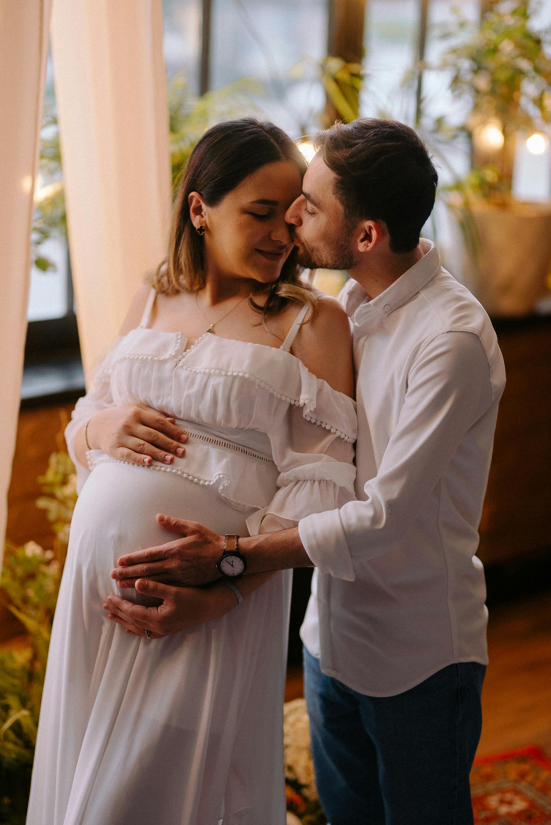 Un homme embrassant et serrant dans ses bras sa femme enceinte | Source : Pexels