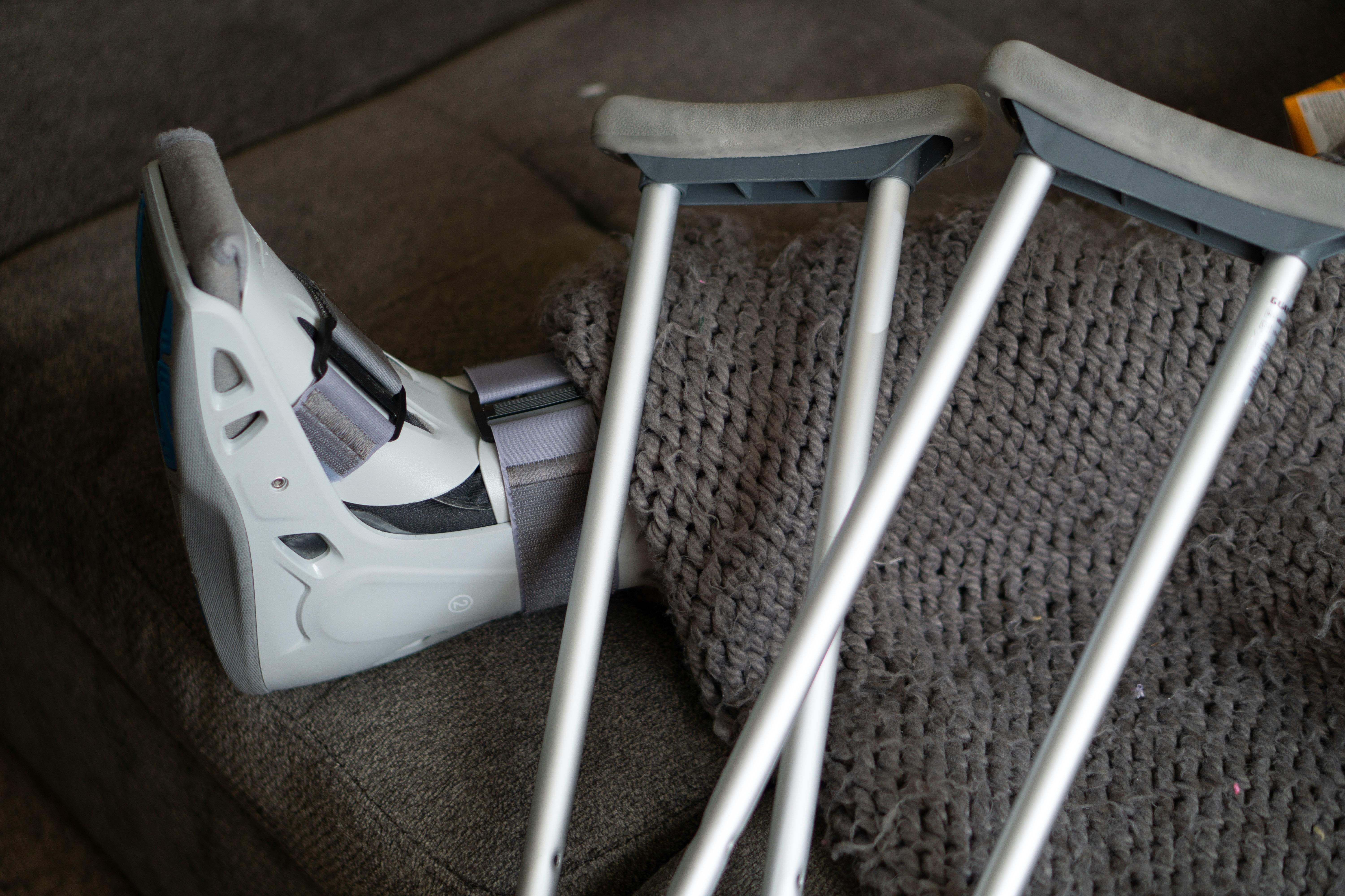 Une personne portant une botte orthopédique et une paire de béquilles | Source : Pexels