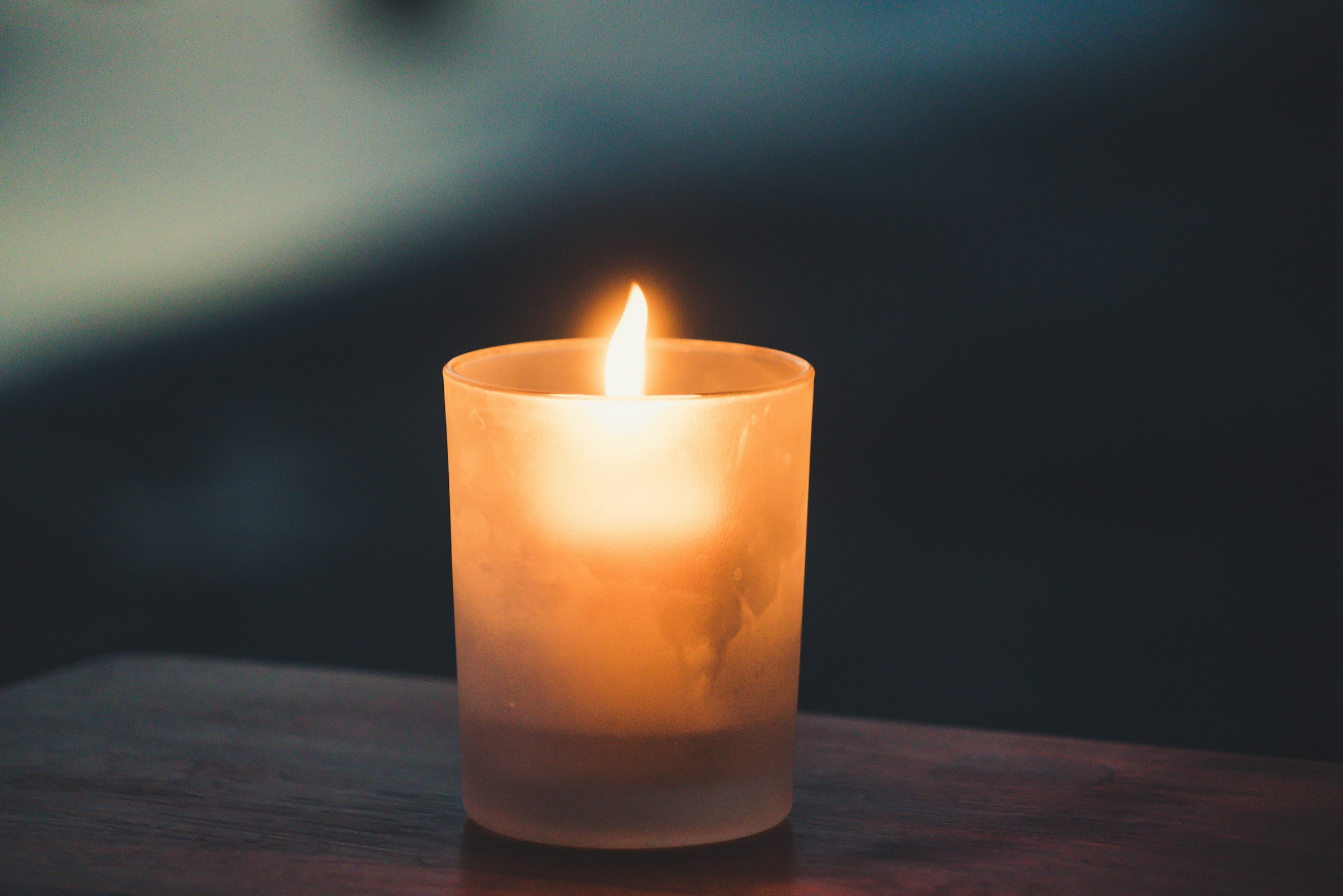 Une bougie allumée sur une surface en bois | Source : Unsplash