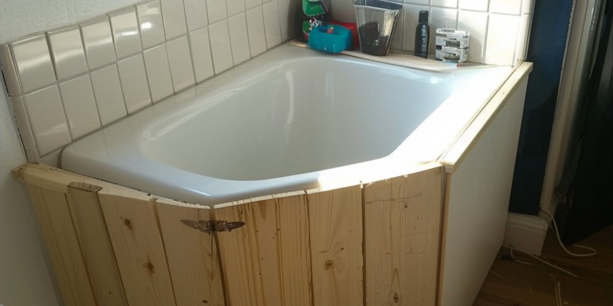 Une baignoire d'angle avec des panneaux décoratifs en bois | Source : Ozdomedia