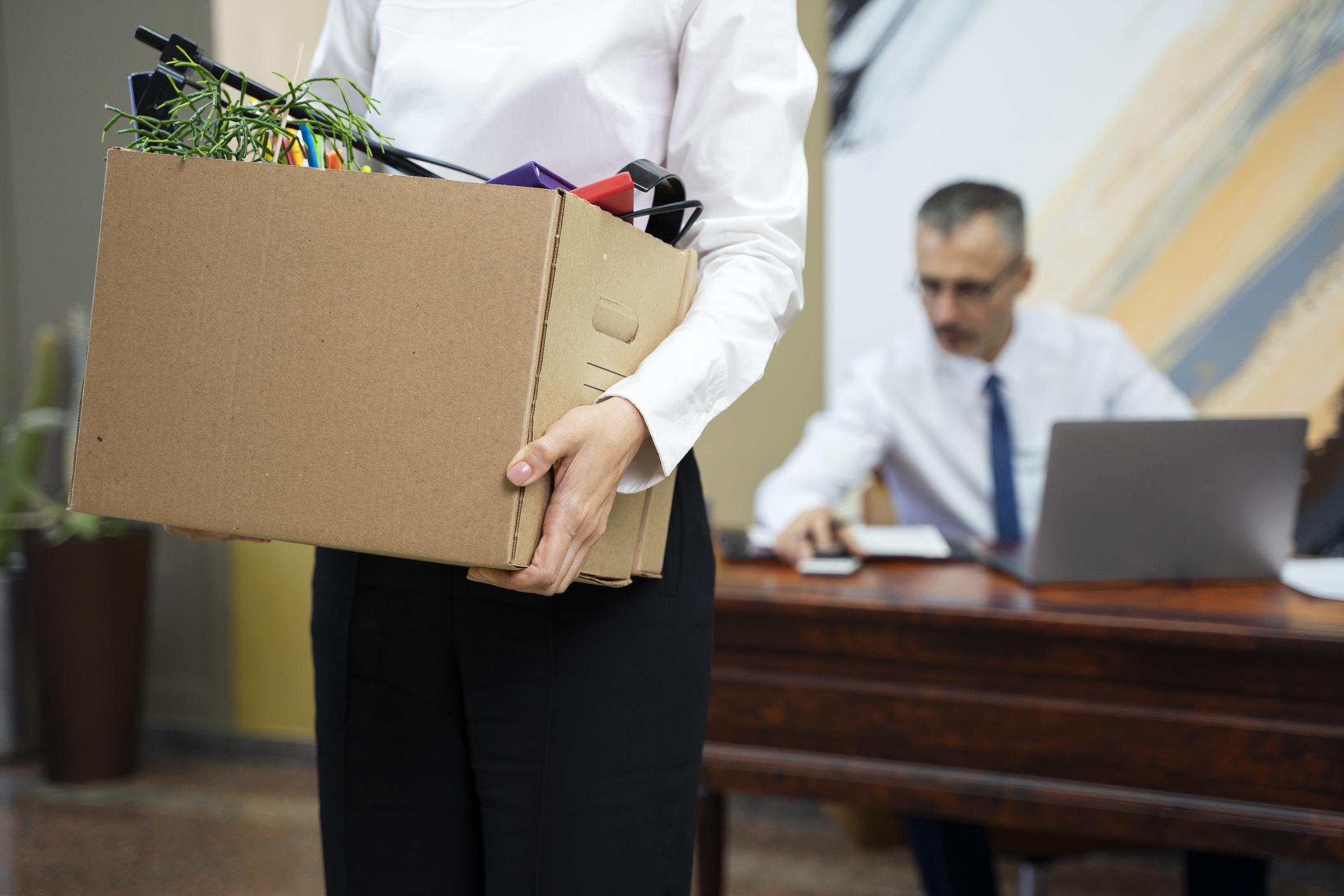 Une femme portant une boîte après avoir été licenciée | Source : Freepik