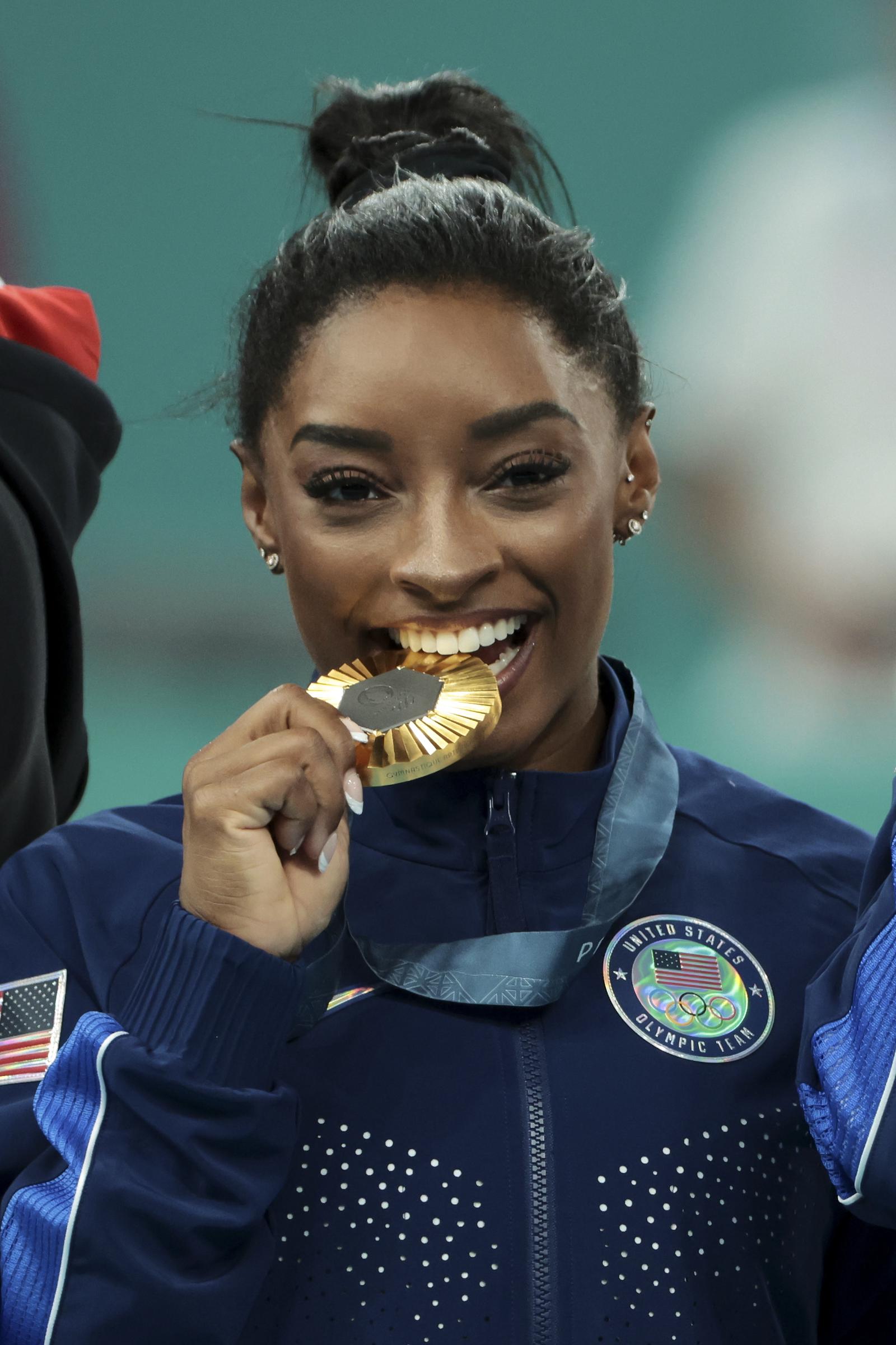 Simone Biles célèbre sur le podium lors de la cérémonie de remise des médailles pour la finale par équipe féminine de gymnastique artistique, le quatrième jour des Jeux olympiques de Paris 2024, à la Bercy Arena, le 30 juillet 2024 à Paris, en France. | Source : Getty Images