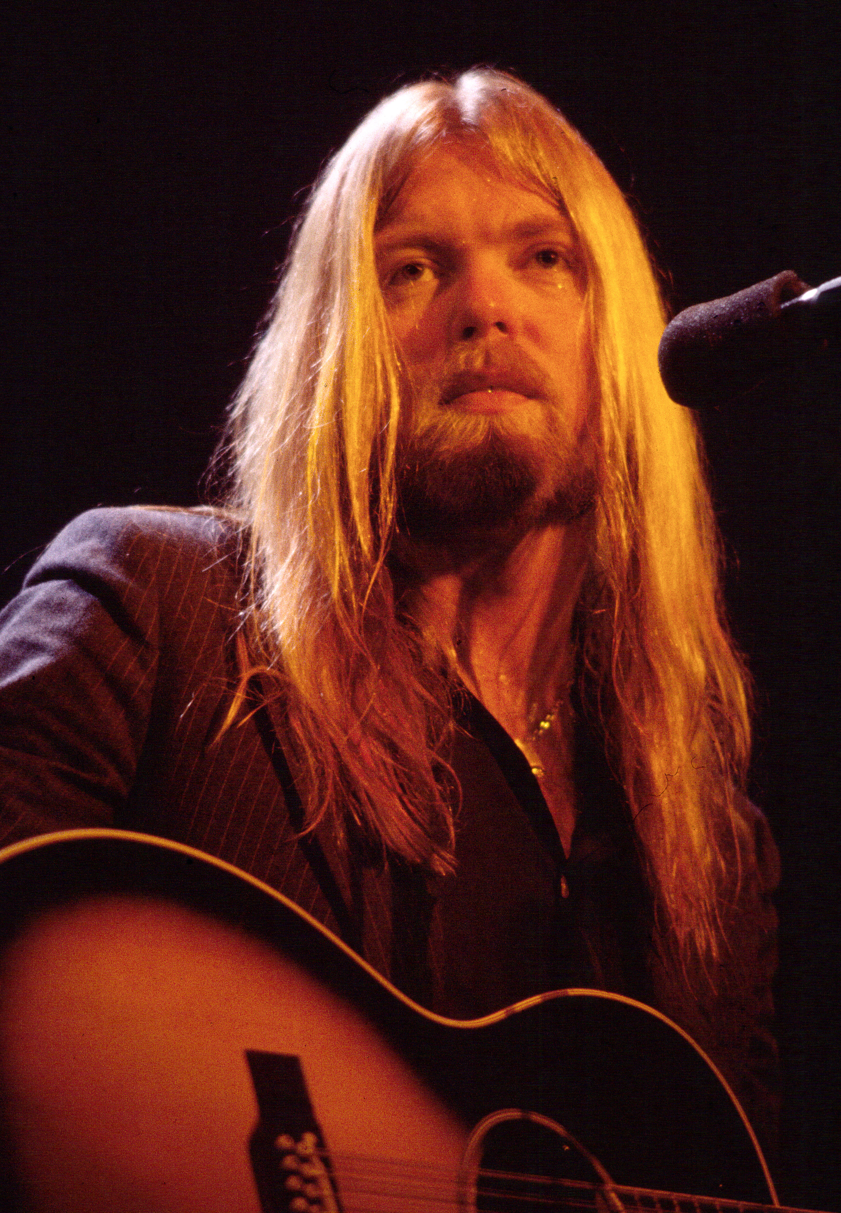 Gregg Allman qui joue de la guitare alors qu'il se produit sur scène au Capitol Theatre de Passaic, New Jersey, le 16 décembre 1981. | Source : Getty Images