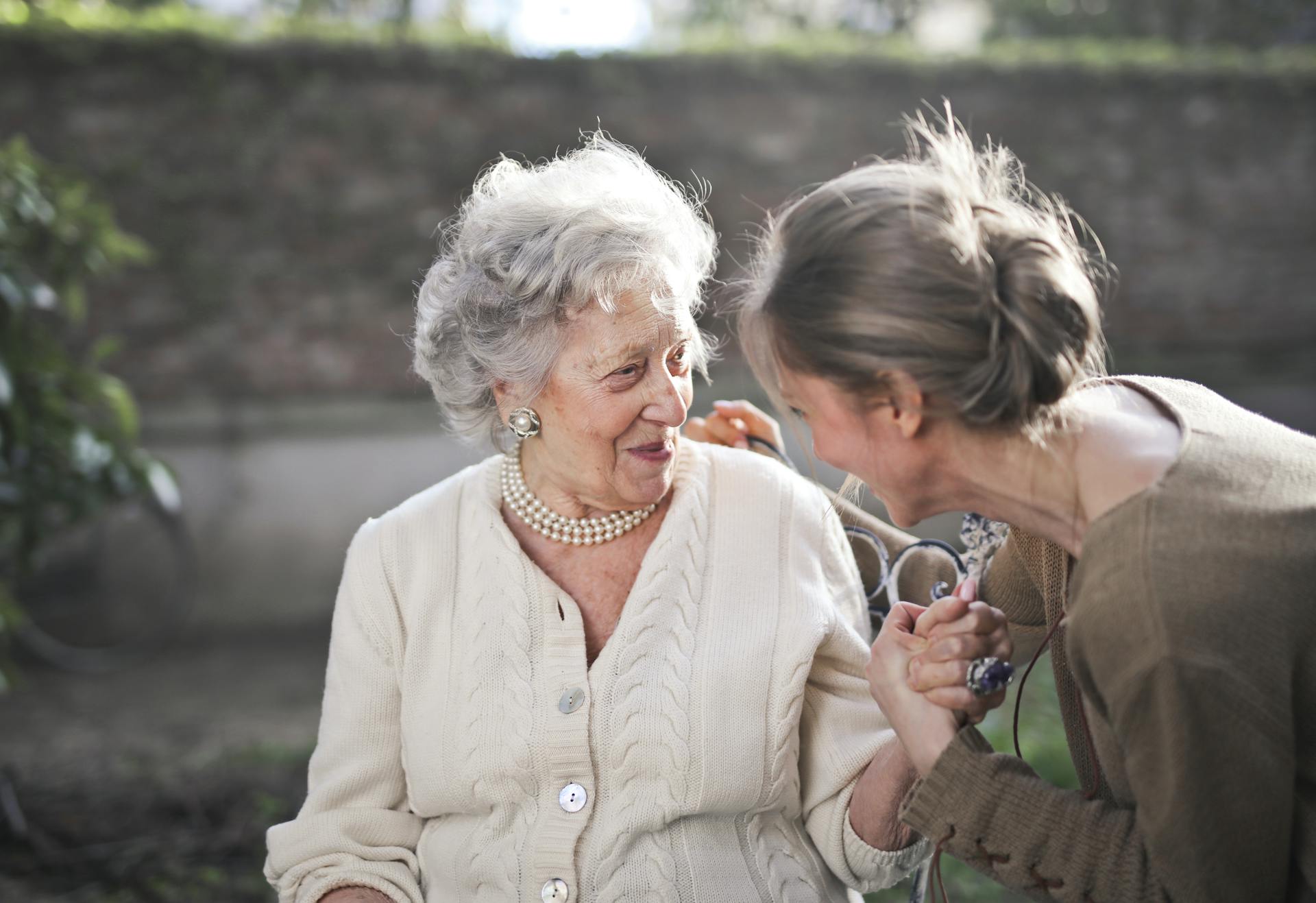 Une grand-mère sourit en parlant à sa petite-fille | Source : Pexels