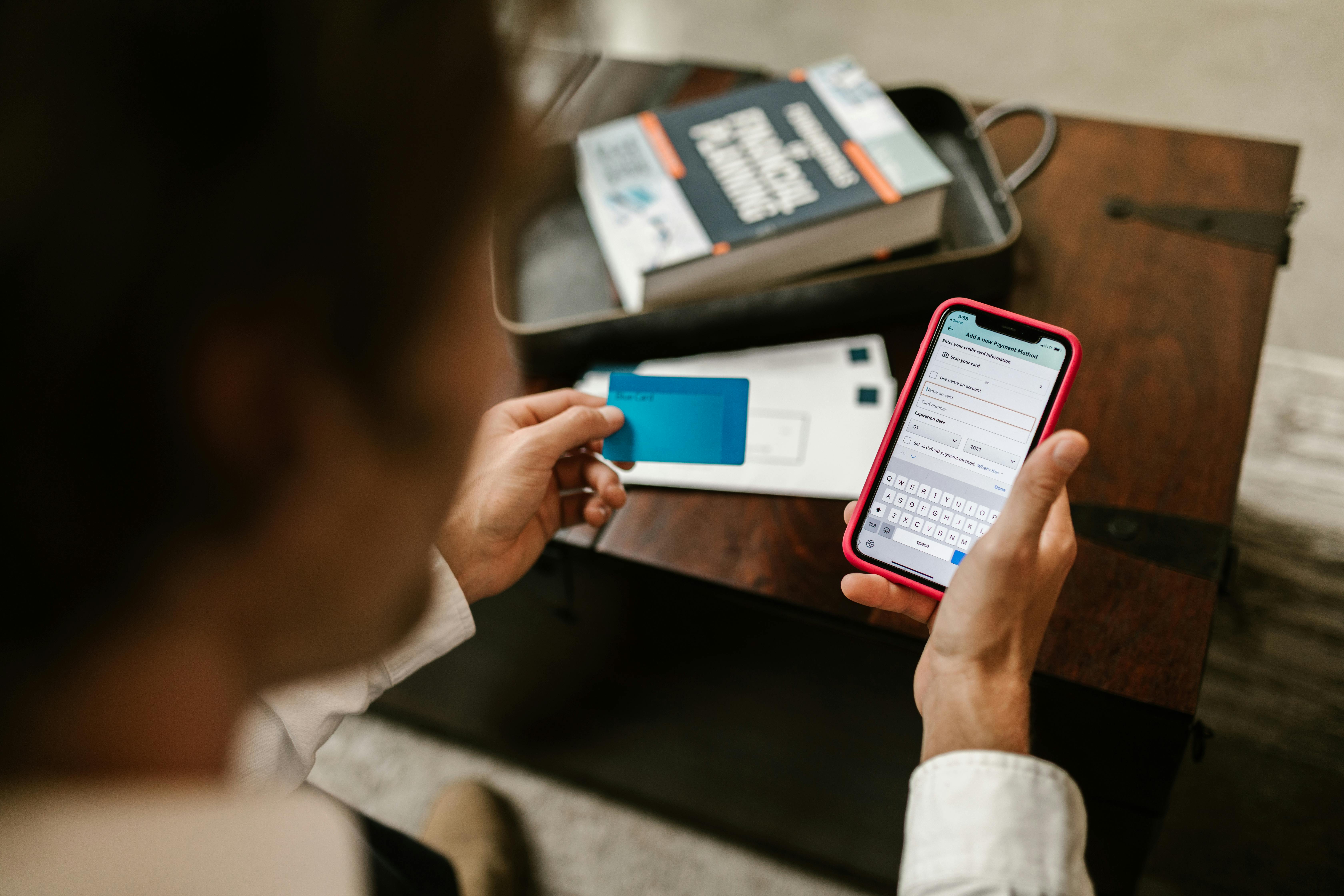 Une personne tenant une carte bancaire et un téléphone portable | Source : Pexels