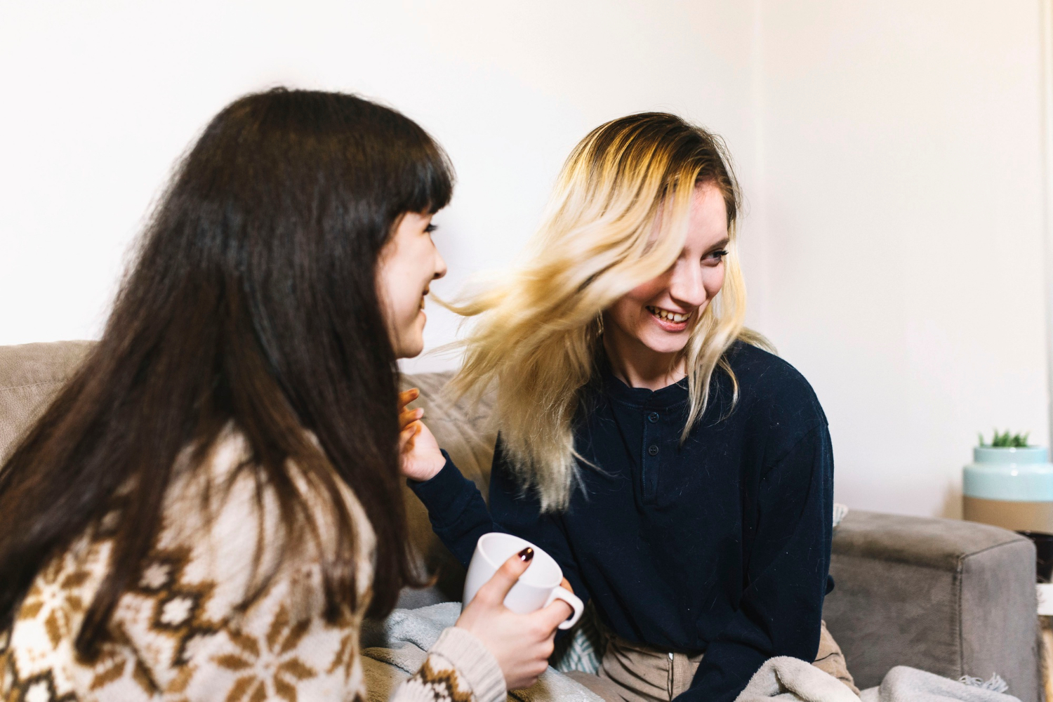 Deux femmes souriantes assises sur un canapé | Source : Freepik