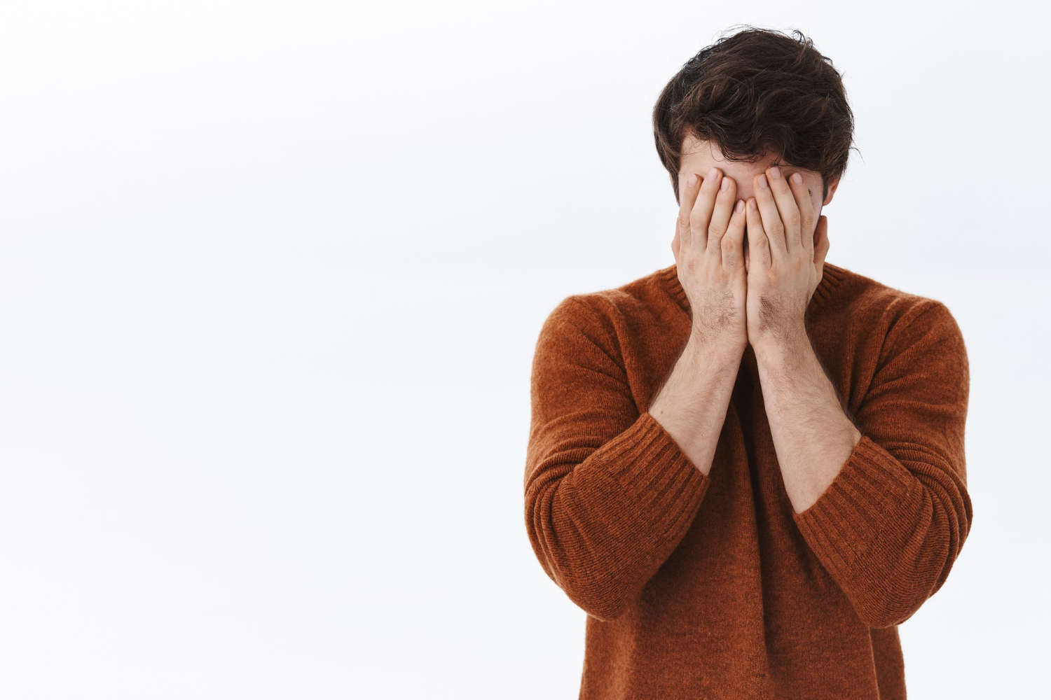 Un homme triste se couvrant le visage | Source : Freepik