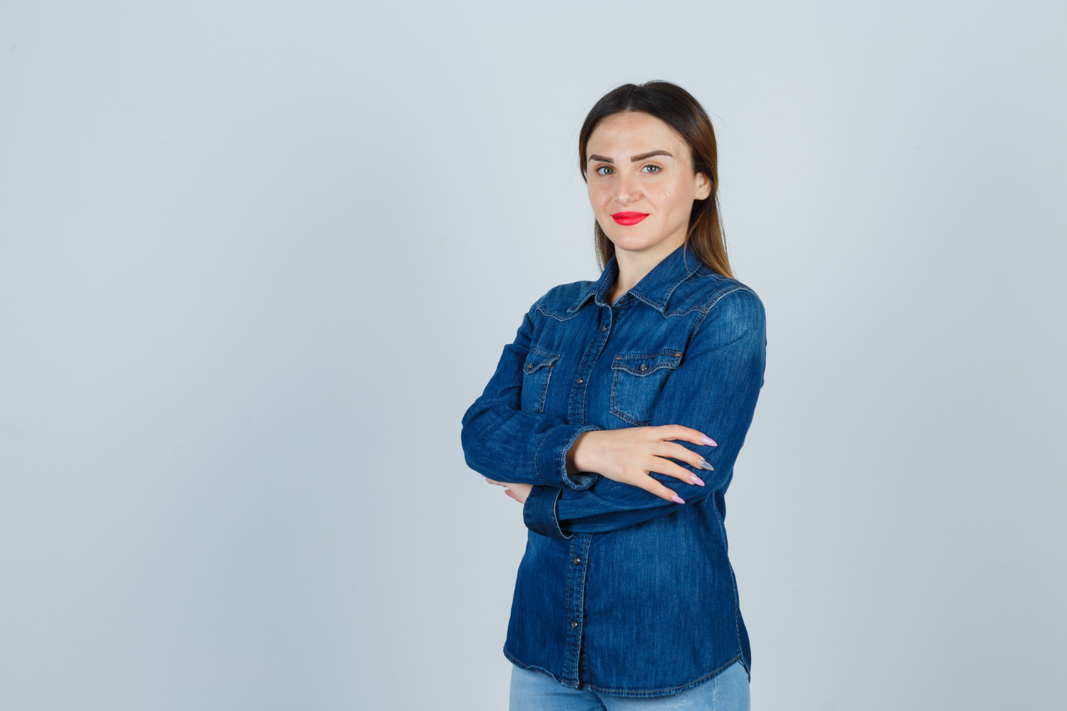 Une femme souriante avec les bras croisés | Source : Freepik