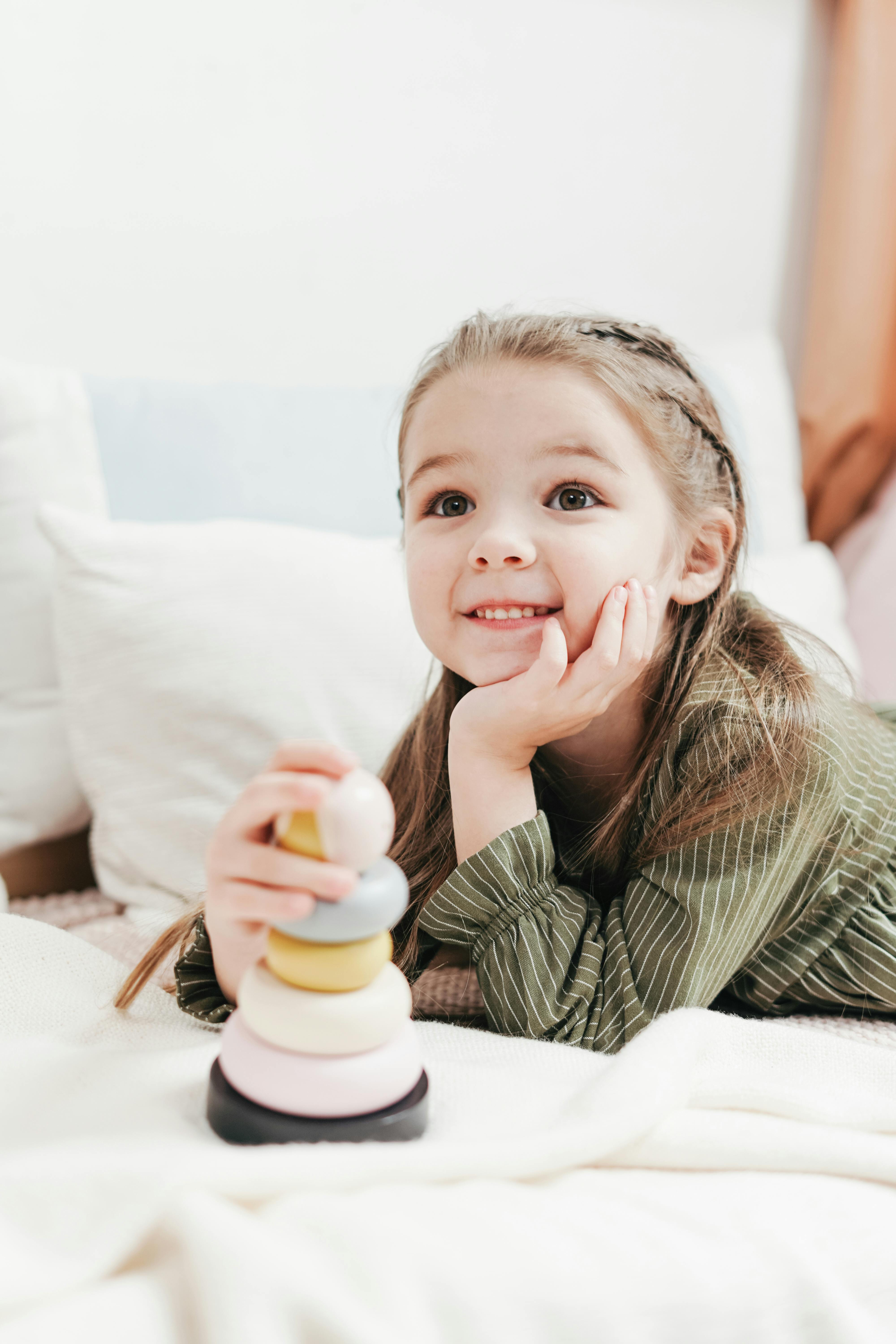 Une petite fille qui sourit en jouant | Source : Pexels