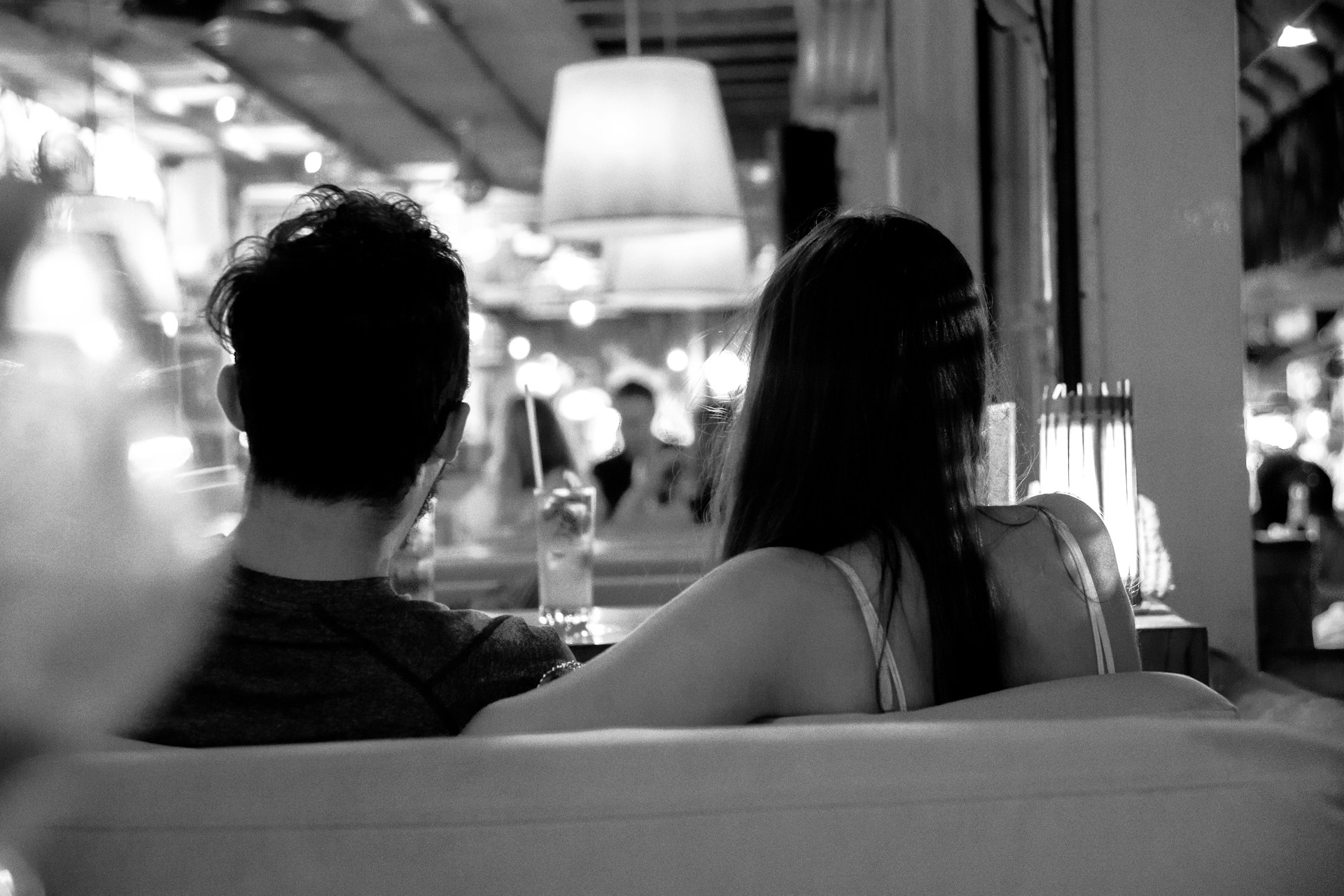 Photo en niveaux de gris d'un couple au restaurant | Source : Unsplash