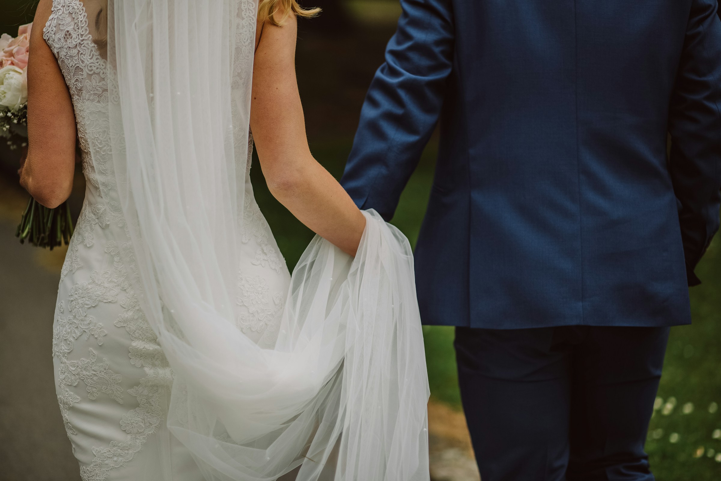 Une mariée et un marié se tenant la main en marchant | Source : Unsplash