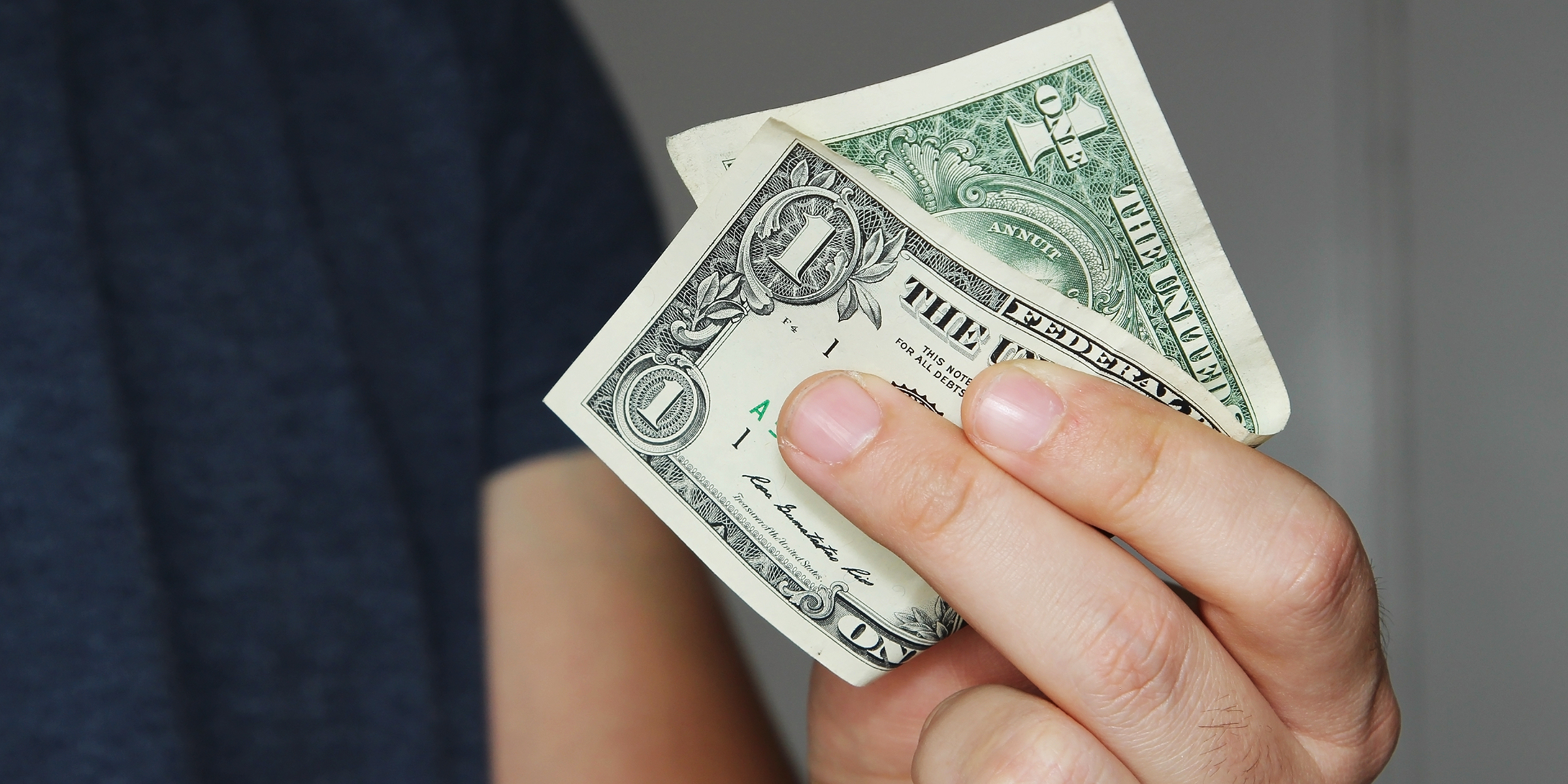Une personne tenant un billet de 1 $ | Source : Shutterstock