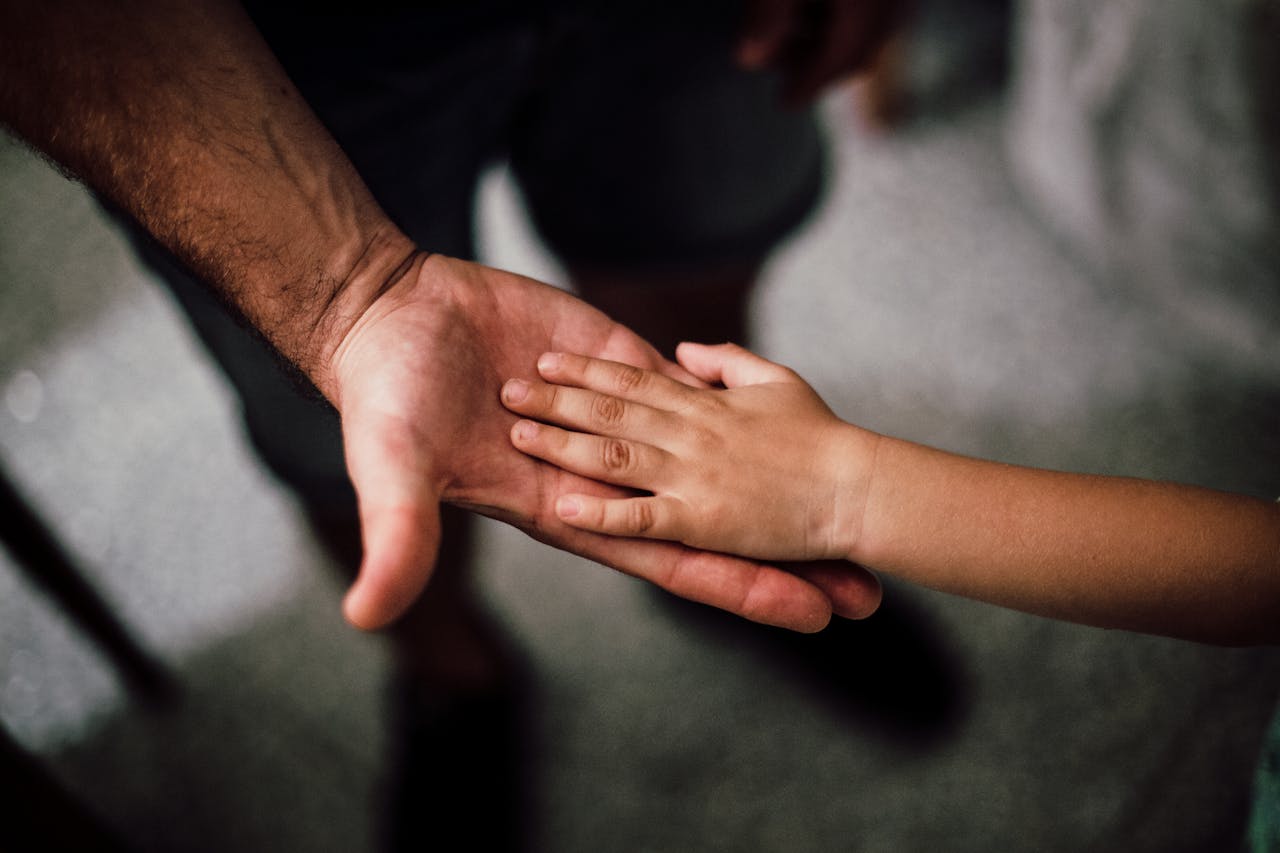Un homme tenant la main d'un enfant | Source : Pexels