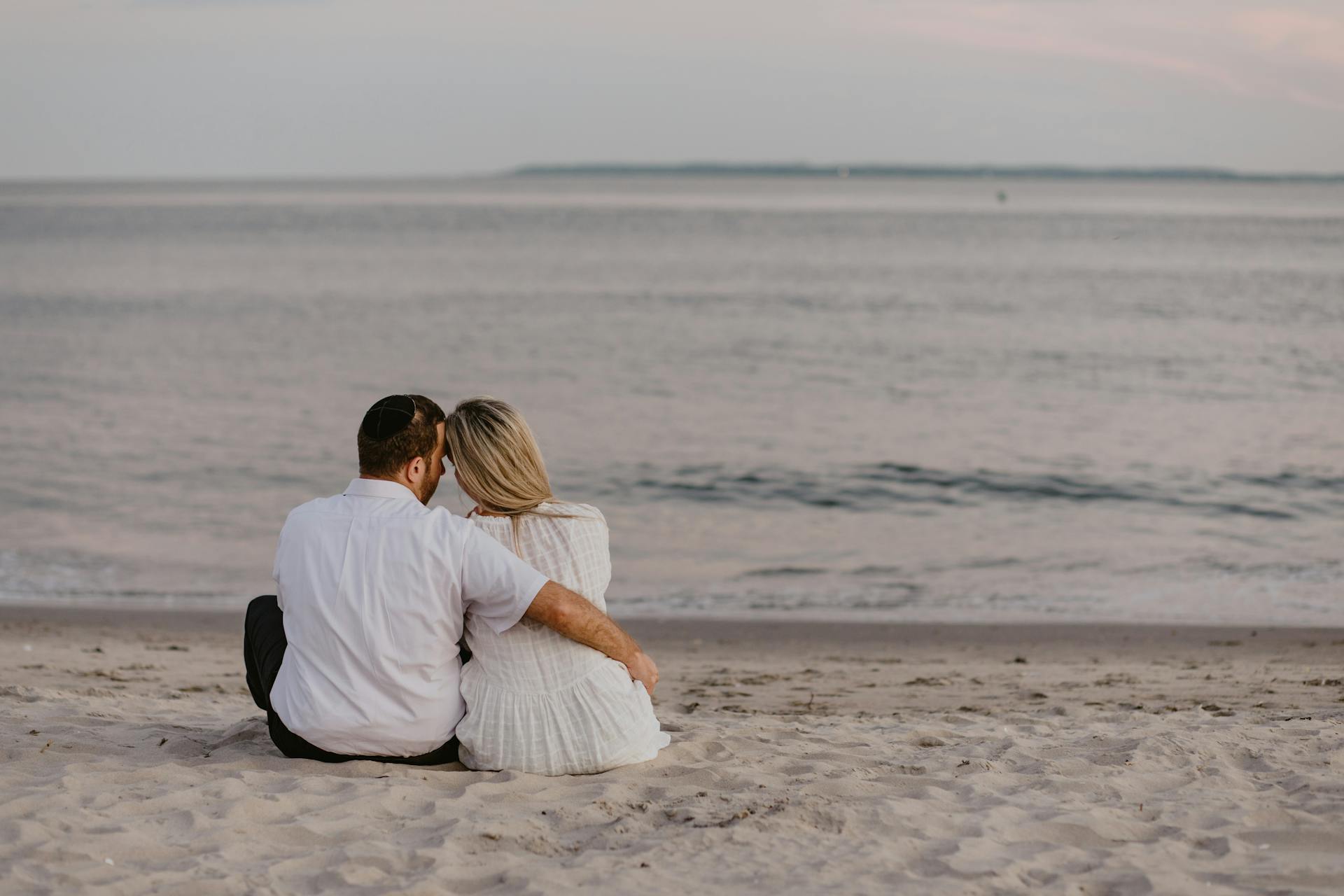 Un couple assis sur la plage | Source : Pexels
